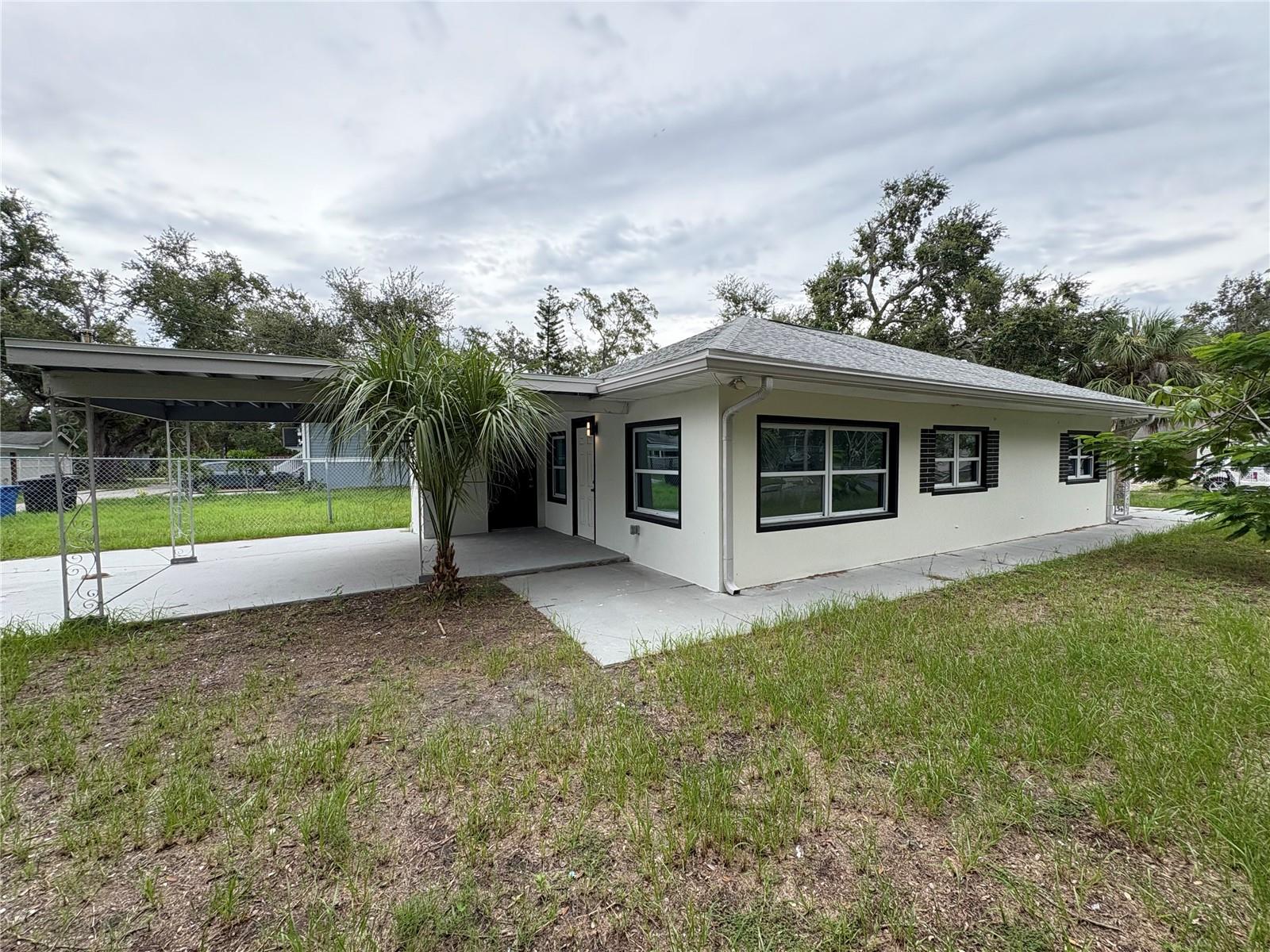 **COMPLETELY RENOVATED GEM JUST MINUTES FROM DOWNTOWN** Step into this beautifully updated single-family home featuring 3 bedrooms and 1.5 bathrooms. Situated on a fully fenced corner lot, it offers privacy and security—perfect for pet owners or anyone who enjoys a little extra space. Every major system has been thoughtfully upgraded, including a new roof (2022), new AC and ductwork (2022), hurricane-impact windows (2016), updated electrical (2021), and a new hot water heater (2022). The sleek modern kitchen is a true showpiece, boasting quartz countertops, stainless steel appliances, and ample cabinet and counter space—ideal for both everyday cooking and entertaining guests. The open-concept layout flows effortlessly, creating a bright and inviting atmosphere throughout. Modern tile flooring runs through the entire home, enhancing both style and durability. The main bathroom features a stunning walk-in shower and a contemporary vanity and there is a half bath is located in the external laundry room. Fresh interior and exterior paint give the home a crisp, new feel. Outside, you'll find rear off-street parking, a large carport, a storage area, and plenty of room to park a boat, RV, or even add a small pool. Located just minutes from vibrant downtown St. Petersburg, only 15 minutes from the Gulf of Mexico’s pristine beaches, and a quick 40-minute drive to Tampa International Airport, this home truly has it all. Whether you're a first-time homebuyer or just looking for a move-in ready property close to everything, this is the one you’ve been waiting for. ALSO AVAILABLE AS A RENTAL! Don’t miss your chance—schedule your private showing today!