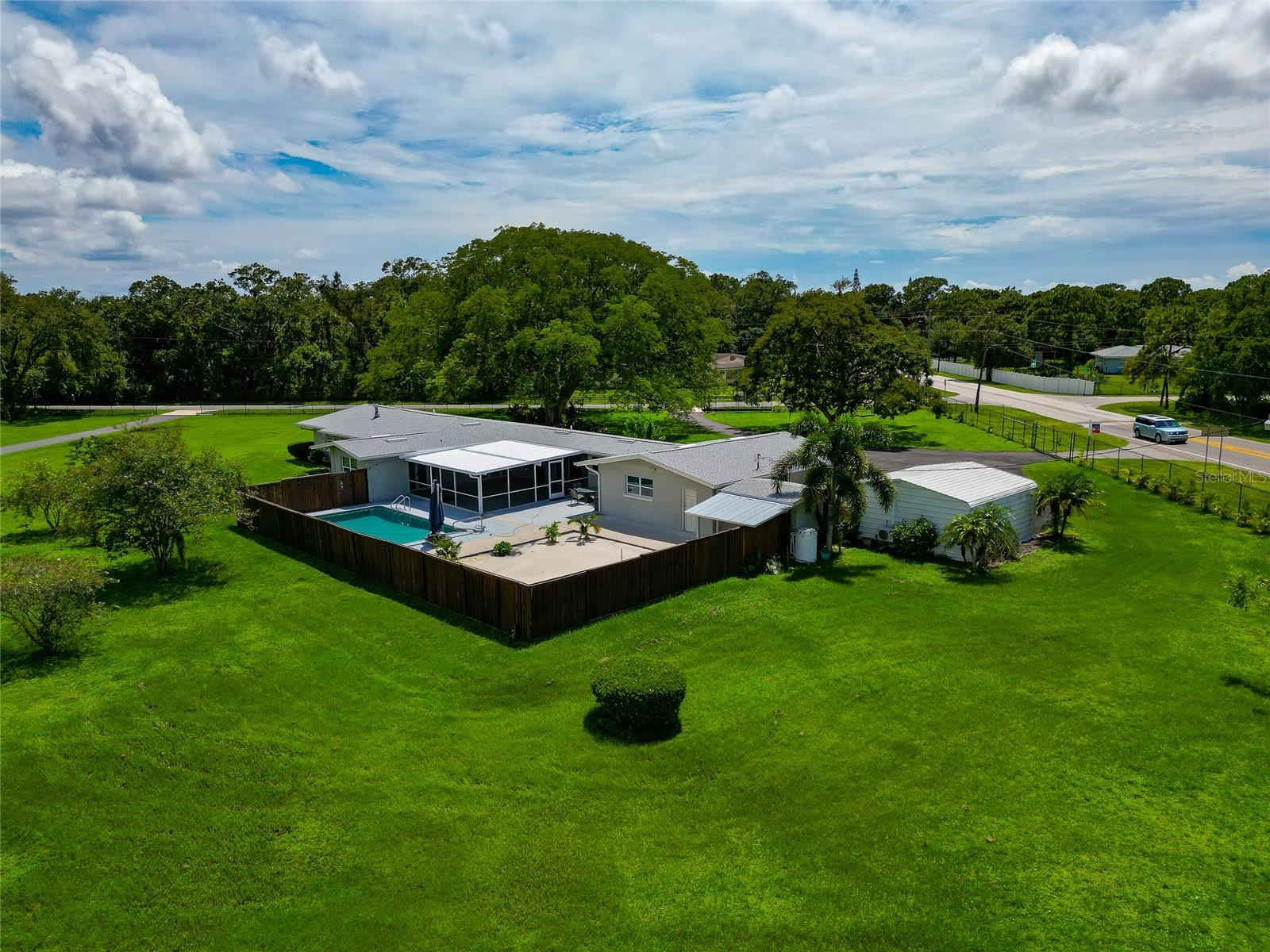 One or more photo(s) has been virtually staged. PRICED TO SELL! 2.23 ACRES, 4-CAR GARAGE, NEW ROOF, NEW WATER HEATER, NEW PAVED DRIVEWAYS AND SIDEWALKS, AND NEW POOL DECK, NEW DOUBLE SEPTIC AND LIFT STATION, AND MORE!! Discover rural serenity in the heart of Sarasota with this beautifully landscaped RE1 Residential Ranch Home, set on a sprawling 2.23-acre lot nestled in a popular equestrian neighborhood, Desoto Acres. Conveniently located just 5 miles from the University Town Center (UTC), 4 miles from Downtown Sarasota, and 8 miles from the pristine sugar sand beaches of Lido Key, St. Armand’s Circle and Siesta Key. This charming 3-bedroom, 2.5-bath home in Desoto Acres offers a New Roof, an oversized attached 2-car garage with a workshop, and an additional unattached 2-car garage equipped with air conditioning, perfect for any workshop needs or temperature controlled storage. A new independent entrance alongside an additional paved driveway and culvert features 200 feet of new asphalt leading to a freshly constructed 40x60' blacktop parking lot. This setup is ideal for a potential future mother-in-law suite, a small pool or patio home, a hobby workshop, a man-cave, or extra space to park your boat or RV. RV enthusiasts will appreciate the designated Driveway, Parking and 50-amp connection, adjustable to 30 amps if needed. The fully fenced yard features multiple gates, one with an automatic remote controlled opener. Step inside to an expansive great room with built-in entertainment features and a large picture window framing the front lawn with majestic trees and gardens. The home boasts recessed ceiling lights, crown molding throughout, and arched entryways leading to the foyer and dining room. The elegant dining room includes recessed glass shelves, built in cabinets, and French doors opening to a spacious covered, screened-in porch. Imagine entertaining on this generous porch that features a pass-through window and sliding glass door to the kitchen. Enjoy an evening swim with the convenience of French doors providing direct access to the master bedroom. The backyard is an oasis, featuring a secluded 14x28 tiki bamboo-fenced pool resurfaced in 2017, adjacent to a private sugar sand beach area perfect for outdoor activities like volleyball. This home also offers three generously sized bedrooms, along with ample storage and closet space. The galley kitchen features newer stainless steel appliances, a breakfast bar, and cozy nook. Bring your horses, boat, RV and all your toys! This estate comes with NO HOA’s, NO CDDs, NO Deed Restrictions! Come and explore the perfect blend of rural charm and urban convenience at 5310 Tuttle Rd! **All furniture and furnishings are personal property and are not included in the sale of this property**
