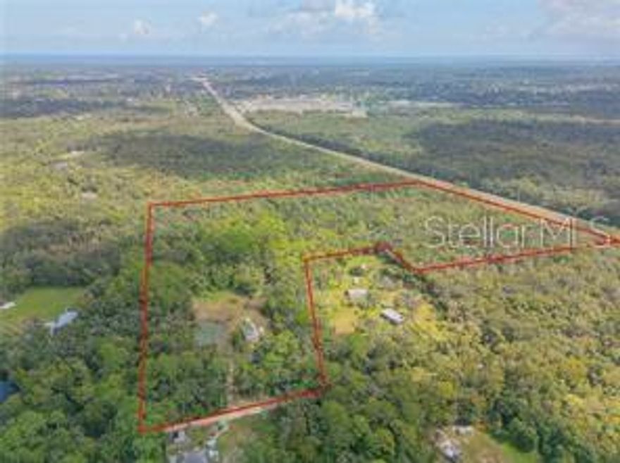 23.75 acres centrally located 15 minutes to the beach, a few minutes east to shops, groceries and restaurants. Over 600 ft. of frontage along Indian River Blvd. (SR442), with an L-Shape to Hideaway Lane (over 400ft. frontage), 6.98 acres of upland, 2.75 acres of upland buffer, with recent 2/1/24 survey. Partially cleared property includes 60x30 cement floored storage building with electric and water. Perfect location for a storage facility, Boat or RV covered storage along W Indian River Rd. The city of Edgewater is moving its offices to the this area and many of the parcels are already sold along this four-lane paved divided highway just off I-95. This is in the immediate vicinity of Miami Corps three development sites proposed to add nearly 33,000 homes and over 9 million sq.ft. of commercial space. Includes parcel ID's: 843801000700, 843801000710, 843801000720