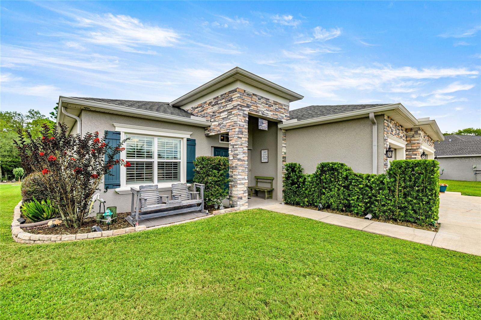 Absolutely pristine 2021 Westin model home! This 4-bedroom, 3-bathroom, 3-car garage residence sits on an oversized .45-acre lot with no rear neighbors, offering the perfect blend of privacy and elegance in the sought-after Kingsland Country Estate. Outshining new construction, this home is loaded with upgrades and thoughtful details throughout. From the moment you arrive, you’ll be impressed by its stunning curb appeal—mature landscaping, rain gutters, and striking stonework. A convenient side path leads you directly to the expansive back patio and screened lanai, ideal for year-round enjoyment. Inside, a grand 8-foot double-door entry welcomes you into soaring ceilings with crown molding, plantation shutters, and luxury vinyl plank flooring that flows seamlessly throughout. Designed for both comfort and entertaining, this home features a formal living room and a spacious great room. The chef’s kitchen boasts white shaker cabinets, timeless subway tile backsplash, granite countertops, stainless-steel appliances, a closet pantry, and a generous breakfast bar. The primary suite is a retreat in itself with a tray ceiling, stylish matching ceiling fan, dual sinks, soaking tub, shower, and an oversized closet. Perfect for multi-generational living, one bedroom includes a convenient kitchenette for an in-law suite, while the adjacent bath features grab bars and a lowered tub entry for added accessibility. Outside, enjoy a 12x24 workshop, invisible pet fencing, and your very own pear, apple, and key lime trees. Furnishings negotiable outside of home sale. All this, just 11 minutes from Hwy 200 with endless options for shopping, dining, fitness, and medical care. If you’re seeking a newer, meticulously maintained home with abundant upgrades and versatile living space, this one is a must-see!