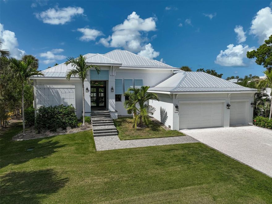 This custom-built home received the "Best Overall" award in the 2021 Manatee and Sarasota County Parade of Homes. Experience the pinnacle of Siesta Key waterfront living in this 2019-built masterpiece by Nutter Custom Construction. Designed with precision and built to last, this solar-powered coastal retreat sits on high elevation and spans over 3,400 living square feet, offering 3 bedrooms, 3 baths, and two versatile flex rooms that redefine modern island living. Every element blends elegance, performance, and peace of mind. You walk into a wide-open floor plan that immediately draws you in. To the left, the primary suite offers total privacy with a spacious bedroom, spa-inspired bathroom featuring double vanities, a soaking tub, glass-enclosed shower with 4 shower heads, and a private outdoor shower with 2 shower heads connected directly to the master bath - a truly open-air sanctuary. To the right, your dedicated office provides focus and functionality, while the heart of the home opens to expansive living and dining spaces with a chef’s kitchen showcasing high-end cabinetry, premium flooring, designer lighting, and top-of-the-line Sub-Zero and Wolf appliances. Each guest bedroom includes its own private en-suite bath, offering comfort and privacy for family and visitors alike. A large walk-in pantry and laundry room are conveniently positioned near the kitchen. A whole-home water softening system, an In-wall pest control system with access ports, 2 air conditioning systems to keep the home evenly comfortable during the warmest weather, and 2 tankless water heaters to provide plenty of hot water.  An oversized three-car garage for everyday ease. An additional flex room opens to the pool through oversized sliders, perfect for a second office, game room, or guest suite. There are automated window shades in the living room and game room. The home runs entirely on solar power and includes a multi-room sound system that fills the home and outdoor living space with your favorite music. Massive hurricane-rated sliding glass doors wrap the back of the home, creating a seamless flow to your backyard oasis, including landscape lighting and an irrigation system. An Integrated Security System with perimeter cameras provides extra peace of mind. Step out onto the beautiful travertine pool deck, featuring a heated pool and champagne-edged spa, outdoor lounge, and covered dining area with a built-in outdoor chef's kitchen powered by propane, perfect for entertaining in style, and all with a sunset view. Beyond the pool, enjoy a lush, manicured backyard with direct access to the wide Siesta Key Grand Canal. A dedicated 14,000-pound boat lift allows you to launch your boat with ease, making days on the water effortless. A separate private docking area is available for your friends to arrive by boat or for jet skis. Enjoy kayaking, paddleboarding, and scenic canal rides, or simply relax and take in the sunsets from your extended concrete pad with a built-in concrete firepit, ideal for gatherings by the water. Every detail of this home is custom-crafted, from its hurricane-rated construction and elevated-lot placement to its energy-efficient systems and timeless coastal design. 5058 Windward Ave isn't just a home, it's a statement in waterfront living: high elevation, solar-powered, elegant, and built for those who expect the very best on Siesta Key.