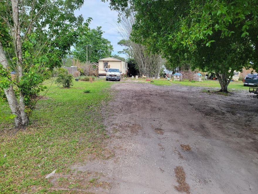 Peaceful lifestyle without restrictions:  3 bedroom, 2 bathroom open floor plan single wide situated on spacious land (.86 acre ) with no HOA.  Large covered deck off the front of the home with smaller deck in back of home.  Entire property is fenced with gorgeous landscaping and mature trees.  This is truly country-style living while still being conveniently located near town.  Within short distance to  Melbourne Beach. Approximately an hour from the world-famous attractions of Walt Disney World.