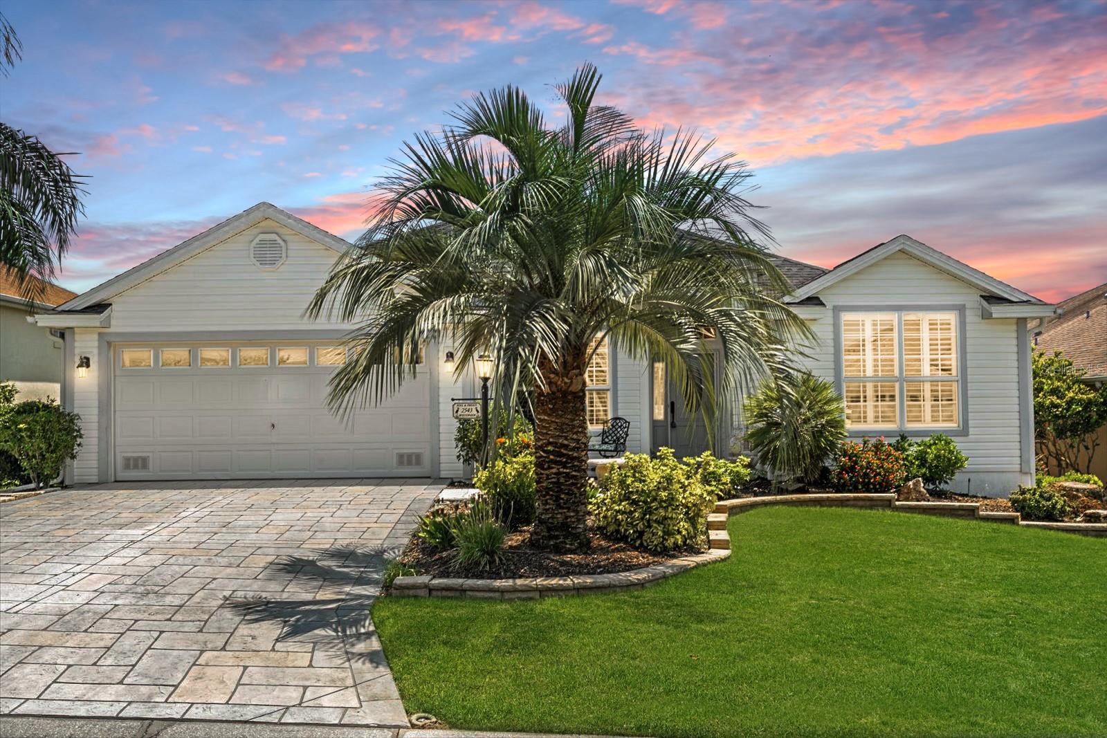 POPULAR FLOOR PLAN IN THE VILLAGE OF HADLEY! This 3-bedroom, 2-bathroom home offers beautiful curb appeal with a stamped concrete driveway, stacked-stone landscaping, rock-filled flower beds, and towering palm trees that frame the property. Inside, the kitchen shines with maple toffee cabinetry, under-cabinet lighting, a tiled backsplash, pendant lighting, and newer quartz countertops. Both bathrooms feature granite countertops for a consistent, upgraded look. The kitchen is equipped with stainless steel appliances, including a brand-new dishwasher and stove, a French door refrigerator (2017), and a microwave (2017). Other updates include a 2023 water heater, 2020 HVAC system, and a new roof installed in April 2025. Throughout the home, plantation shutters adorn every window, adding timeless elegance. The acrylic-enclosed, tiled lanai features a Mitsubishi mini split system, making it a comfortable space year-round. Flooring includes ceramic tile in all wet areas, wood-look tile in the living and dining rooms, and carpet in the bedrooms. The master suite boasts dual vanities and a Roman shower, while the backyard patio offers a pergola, perfect for relaxing or entertaining. The washer is also brand new for added convenience. The 3rd bedroom does not contain a closet. Located in the desirable Village of Hadley, you’re just minutes from the Havana Country Club and Colony Plaza Shopping Center, which includes a Publix and other shops and dining. This home combines quality updates, thoughtful design, and a prime location in the heart of The Villages!