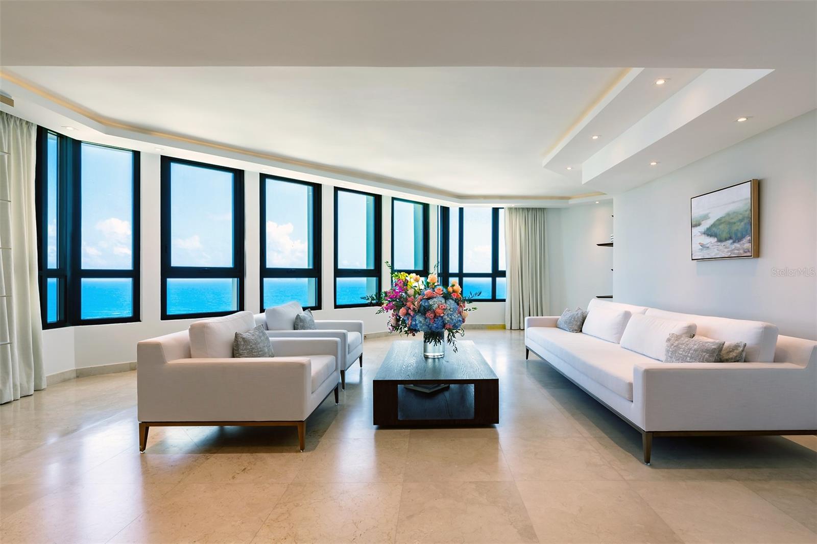 Experience the Pinnacle of Luxury at Caribe Plaza’s Sub-Penthouse
Elevate your lifestyle to new heights with this extraordinary sub-penthouse at Caribe Plaza, perched on the 20th floor. Spanning an impressive 7,187 square feet across two levels, this mansion in the sky offers unparalleled city living with breathtaking views of the turquoise ocean skyline. This is the only condo of its size currently available in San Juan, making it a unique opportunity for discerning buyers.
Begin your day by savoring your morning beverage on your private terrace, where the sweeping ocean views and vibrant sunsets create a perfect backdrop. As night falls, the twinkling city lights provide a stunning contrast, ensuring every moment in this home is nothing short of magical.
Upon entering your private lobby, you’ll find a spacious main level featuring a formal living and dining room, a gourmet kitchen equipped with top-of-the-line appliances and custom cabinetry, and a generous entertainment area with a bar, media space, and multiple dining options. The home is outfitted with Sonos speakers throughout, enhancing every occasion with seamless sound. This residence is ideal for hosting gatherings of any size, offering both elegance and comfort.
The second level is dedicated to restful retreats and luxury. It includes three en-suite bedrooms, a family media space, and the primary suite—a sanctuary of opulence. The primary suite boasts a spa-like bathroom with a large soaking tub, dual waterfall shower heads, a coffee station, mini fridge, double vanities, and a massive walk-in closet. The bedroom area, complete with a cozy sitting area, is enveloped by majestic ocean views.
In addition to the luxurious living spaces, this home offers practical amenities such as four deeded parking spaces, a dedicated storage room, a maid’s room/office on the first level, and a spacious walk-in laundry room. These features ensure both convenience and functionality in this exceptional residence.
With its expansive space, stunning views, and full-service concierge building, this sub-penthouse offers a lifestyle of luxury and sophistication that truly has it all.