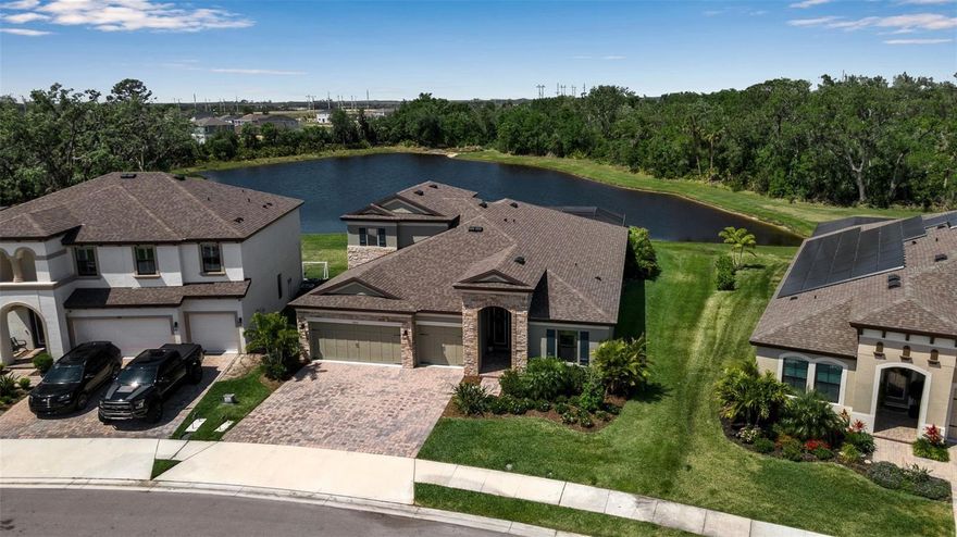 Prime waterfront lot surrounded by conservation in the highly sought-after North River Ranch community. This Homes by WestBay floorplan offers 4 bedrooms, 4 bathrooms, a 3-car garage, and 3,172 square feet of spacious, open-concept living. Enter through elegant double glass doors into an extra-wide foyer—just down the hall are a set of glass french doors that open to a sun-filled flex room, ideal for an office, den, or formal dining room. At the center of the home, the great room features a stunning 12-foot tray ceiling with custom wood beams and flows seamlessly into the deluxe kitchen and dining area. Expansive 24-foot glass sliders open to the extended covered lanai, creating the perfect indoor-outdoor living experience. Step outside to a custom-built pool with an oversized sunshelf, infinity-edge spa, and deep-end bench seating, all framed by Shellock pavers in a diamond pattern, turf accents, and a screened cage with a 50-foot clearview screen overlooking serene pond and conservation views. The first floor includes 3 bedrooms, thoughtfully placed in separate corners of the home for added privacy, along with 3 bathrooms. The private primary suite is located in the back corner and features abundant natural light, two walk-in closets, direct lanai access, and a luxurious en-suite bath with dual vanities, a makeup counter, garden tub, separate shower with glass door, bench, rainfall showerhead, secondary showerhead, private water closet, and large linen closet. Upstairs, you’ll find an oversized bonus room, an additional bedroom, and a full bathroom. The first-floor laundry room leads to the 3-car garage, which has been upgraded with epoxy floors. Residents of North River Ranch enjoy access to exceptional amenities, including nature trails, a resort-style pool, a bike-share program, a dog park, a fitness center, a screened game room, pickleball courts, a bike park, and the new Camp Creek area with a café, social gathering space, workspaces, and a beach-entry pool with water slides. Come tour this beautiful move-in-ready home and experience the views, space, and lifestyle for yourself.