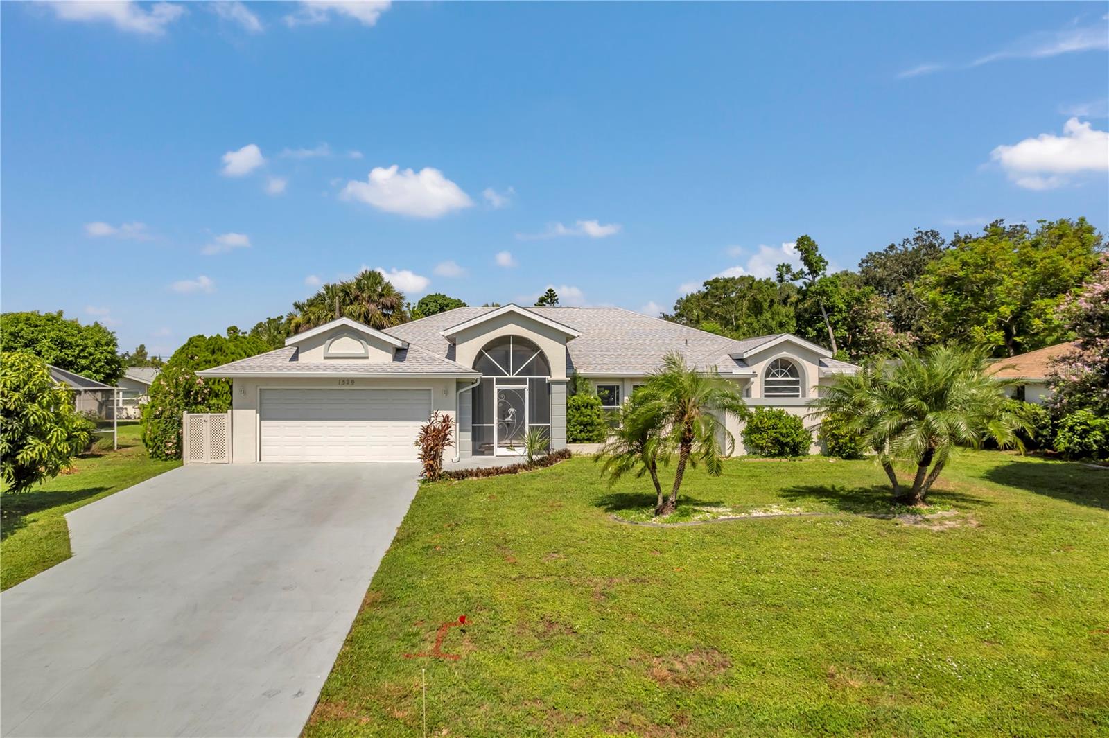 This well-maintained pool home in a quiet, convenient Port Charlotte location is near shopping and hospitals. Mostly tiled, it offers vaulted ceilings in the living and master bedrooms, a kitchen with skylight and pass-through to the pool deck, and a master suite with pool access, twin closets, double vanities, walk-in shower, and soaking tub. The second bedroom has a Murphy bed. Features include a newer roof, pool cage, some impact windows, shutters, and Kevlar hurricane screens on the lanai