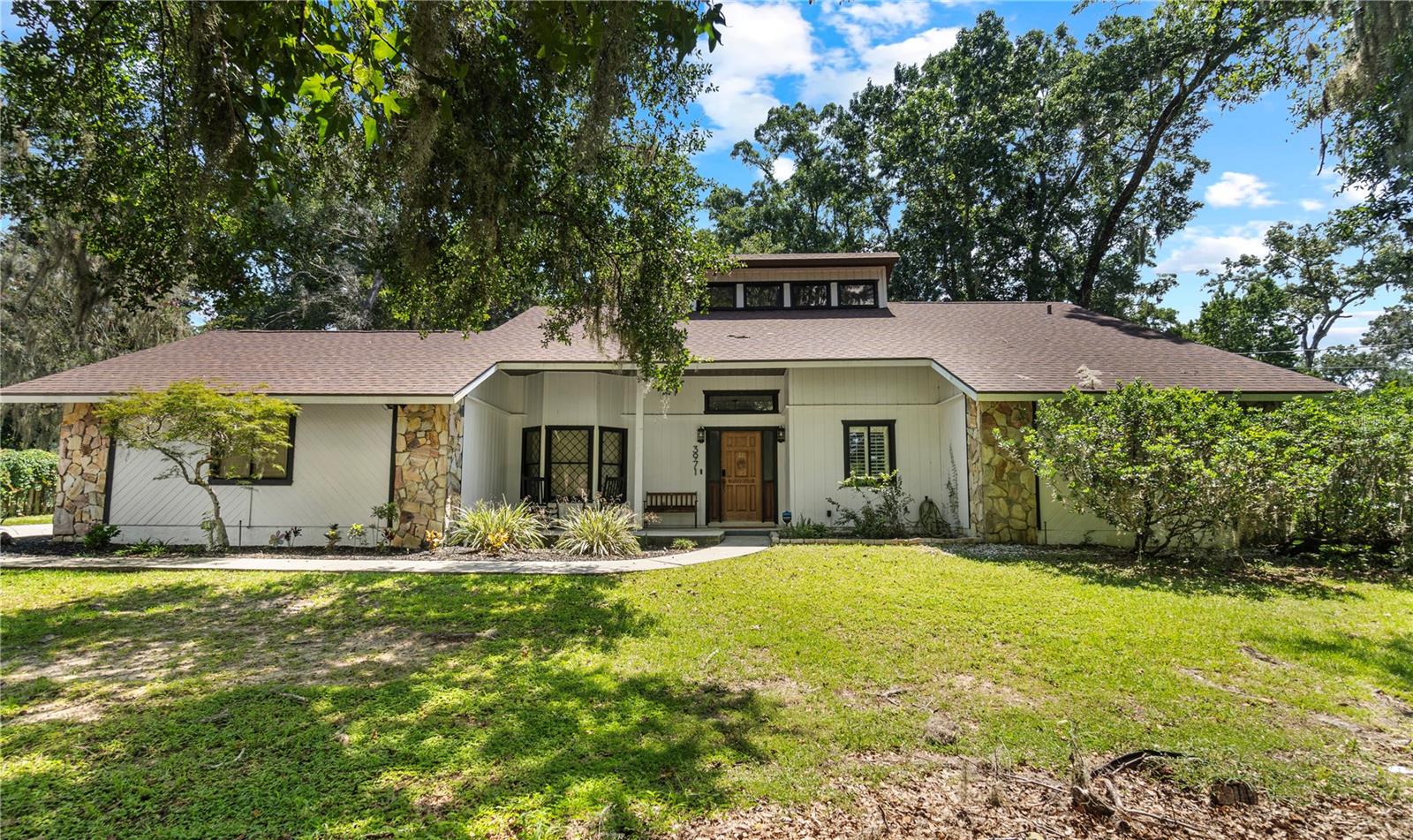 Welcome to this fully updated and modern 3-bedroom, 2-bath home on over half an acre with no HOA in the heart of Southeast Ocala! The owner is currently using the third bedroom as a home office, but it can easily be converted back into a bedroom to fit your needs. Step inside to an open, airy floor plan with a beautifully remodeled kitchen featuring a large island, stainless steel appliances, and plenty of natural light flowing into the spacious living area with soaring ceilings and a cozy stone fireplace. Outside, enjoy a private backyard surrounded by mature trees—perfect for relaxing or entertaining. Located just about 10 minutes from Downtown Ocala, this home combines quiet suburban living with quick access to shopping, dining, and the historic square.