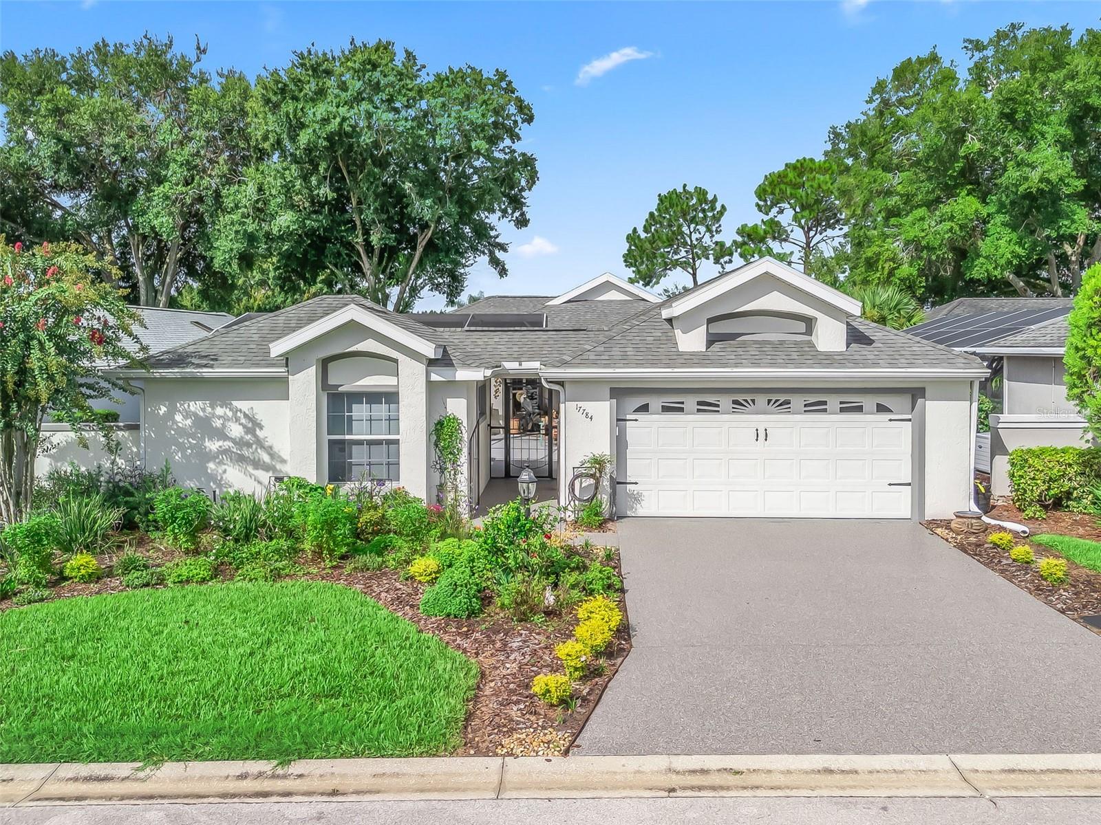 Stonecrest is a 55+ gated golf course community with all the amenities and 4 pools (one indoor),and just a Bridge Away By Golf Cart To The Villages! Come See this Beautiful Pool Home! Stunning 3/3 Concrete, Block, and Stucco Mark V Casita Villa with a 2 Car Garage, Shark Bite Coated Driveway, ROOF 2022, HVAC 2022. This is an Impressive home with an Exceptional floor plan, features a Casita (Bedroom 3) which is Detached with a Private Entrance, Luxury Vinyl Plank flooring, a Bedroom (10x14) with a Walk in Closet (5x6), a Full Bathroom (5x8), and Private access to the Birdcage Enclosed Courtyard which features a Lagoon style Pool with Waterfall! Enjoy Your Own Private Oasis in your Birdcage Covered Courtyard which provides Tremendous Outdoor Living Space, showcasing the Heated Lagoon style Inground Pool with large Swim Out area, a Nice size Covered Lanai, and Multiple seating areas! The main house offers an Open Concept Floor Plan, Vaulted ceilings, Family Room, and a Bonus Room! The recently remodeled Kitchen (2021) showcases a Designer Light Fixture, Granite Countertops, Glass Tiled backsplash, Wood Cabinets, a nice size Breakfast bar, Pantry closet with pullouts, Stainless Appliances, a Skylight and an Eat in Area! You will Love This Open Concept Floor Plan with a Huge Spacious, Light and Bright Living area flows seamlessly to the Dining area with Vaulted ceilings, and Sliding door access to the Courtyard, just perfect for Entertaining Friends and Family or Relaxing in the comfort of your Tropical Paradise! The Recently renovated Luxurious Primary Suite showcases Private access to the Courtyard, a Sitting area, Huge Walk in Closet and an En Suite bathroom. The En Suite bathroom boasts a nice size 2 Sink Vanity, and a Tiled Walk in Shower. Bedroom 2 (no closet) can be used as an office or Family room, and provides direct access to the Bonus room. This Mark V Floor Plan offers maximum Privacy for both the Owners and their Guests, with the Primary suite situated in the main home while the Casita (3 bedroom) and guest bathroom 3 are located on the opposite side of the Courtyard, providing plenty of space, and convenience for your guests. This home offers Plenty of Privacy for both the Owners and their Guests! Relax, and Enjoy Your Own Private Oasis with a Tremendous Outdoor Living Space, featuring Heated Pool (New Pool Heater), Pool deck, Birdcage, Covered Lanai, and a Private courtyard! (This is a Villa, HOA Fee $283.00 per month. HOA Fee Includes: Mowing, Trimming and Lawn Fertilization). Stonecrest is a 55+ gated golf course community with all the amenities, pools, pickleball courts, softball, 18 hole championship golf course, Broad Stripes Golf & Social Club and over 80 different clubs to join! Stonecrest is just a bridge away by golf cart to the Villages. It is a community with Private Roads and 24 Hour Security! As a private gated golf course community, you can expect a high level of privacy and security. Overall, this home offers a combination of Tremendous Outdoor Space, luxurious features, a desirable location, and a secure community setting. A WONDERFUL LIFESTYLE AWAITS YOU IN STONECREST!
