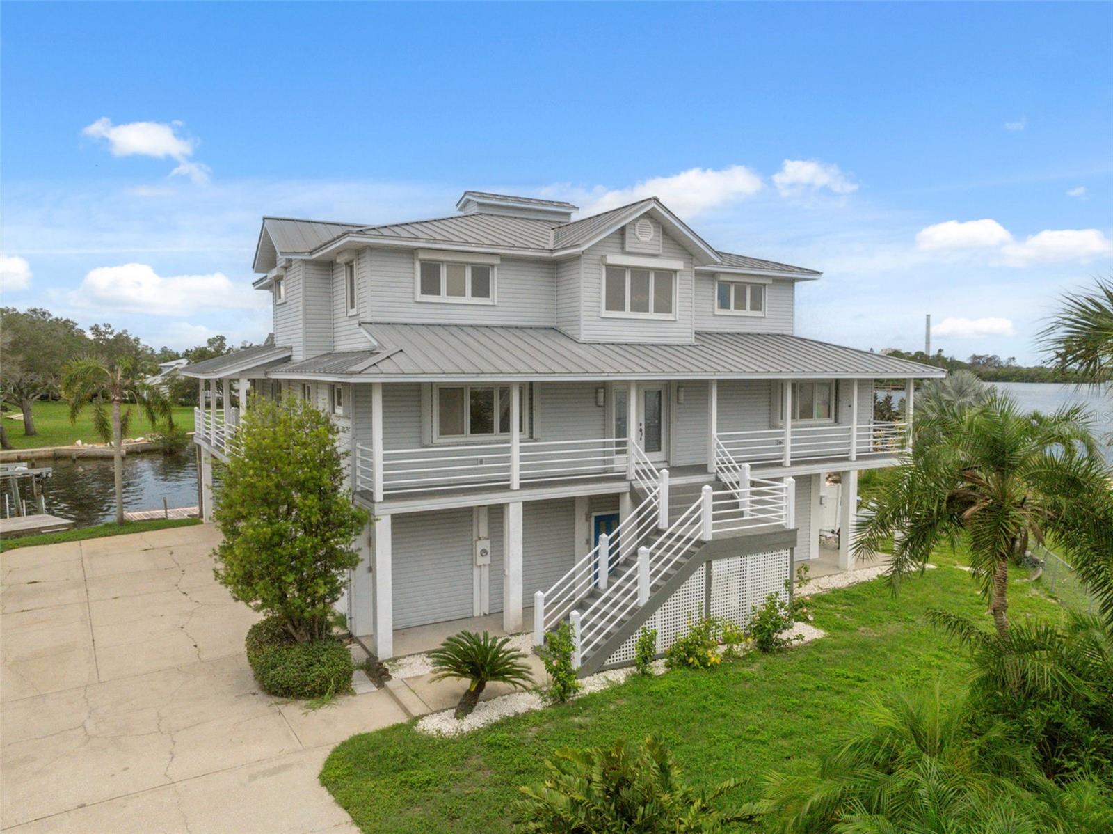 Stunning Ocean views from this waterfront paradise. The opportunity has arisen to acquire the former home of the renowned local artist Elain Hahn. Located in the sought-after Bailey’s Bluff community, this stunning 4-bedroom, 4-bath elevated home offers 3,412 square feet of coastal living with panoramic water views throughout and 160 feet of private water frontage with direct access to the Gulf. Located at the very end of a Cul-de-sac the private driveway leads to a spacious 4 plus vehicle garage. Take the inside elevator to the open plan 2nd floor, with feature light maple hardwood flooring accentuating the amazing natural light that flows into the living room. This floor also contains an open-plan kitchen, dining area, master bedroom suite and artist studio which has the most amazing views you will find for any home office. There is a covered front balcony and wrap around back balcony where you can enjoy the wonderful Gulf breezes. The third floor has three further bedrooms and addition Den/office. Also, you will find a secluded third-floor balcony that looks out at more spectacular views across to Anclote Key. In addition to the ground level garage, there is a covered parking area. Inside the garage is workshop space with French doors onto the pool deck. The backyard has a tranquil, tropical and beach feel with floating dock and boat lift. Take a 15-minute stroll to Key Vista Nature Park with its many trails and observation tower overlooking the Gulf. Enjoy boating, fishing, scalloping and island hopping. A short drive to a recreational complex, parks, beaches and the charming community of Tarpon Springs, complete with shopping and dining options. This home is solidly built to withstand hurricanes, being elevated, and with concertina or roll down shutters to all windows. During last year’s storms only suffered minor damage, not even losing power. There is no HOA, but an optional Baileys Bluff Civic Assoc. membership is just $100 a year, providing a private beach, boat ramp, & clubhouse. Don't miss the opportunity to make this slice of paradise your own! Link to Tampa Bay Times article featuring the home (https://www.tampabay.com/archive/2007/02/24/artist-s-paradise-light-filled-home/)