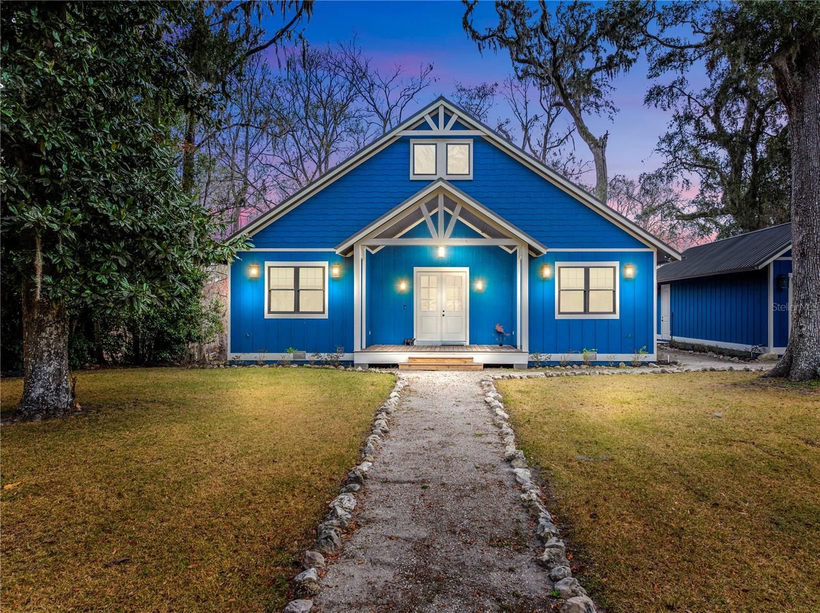 Welcome to your new retreat on the Sante Fe River. This custom built home was completed in 2020 and shows like brand new. Beautiful tongue and groove 19 foot cathedral ceilings greet you upon entry into the great room. Hardwood flooring throughout and shiplap entry walls create a warm and relaxed atmosphere. The home features an open concept great room plan that opens to the kitchen and dining room. The large primary suite features plenty of windows to maximize the river views, a large walk in closet and primary bathroom with an oversized double shower and double vanity. The home has a desirable split floorpan to ensure privacy. The ample guest suite is perfect for family and friends to enjoy weekends on the river. The guest bath has a large shower and double vanity. The kitchen is a chef's dream with solid wood cabinets, GE Cafe appliances and granite countertops. The dining room features walls of windows to enjoy the beautiful water views. The back porch will quickly become your favorite spot for morning coffee, casual meals and an evening watching the local deer feed down by the spring. There is a detached one car garage for all of your water toys and storage needs. The lot is almost a half acre with beautiful mature trees and landscape. Wilson Springs community features a private boat ramp and waterfront park for swimming and launching your boat, jet skis, kayaks and paddle boards. Five miles from the crystal clear Ichetucknee River! Don't miss this one just in time for spring and summer!