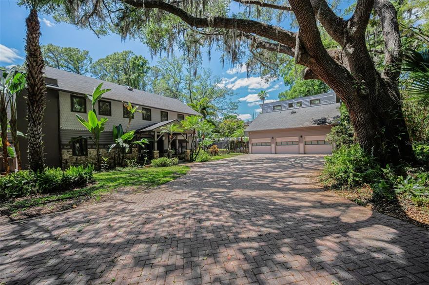 One or more photo(s) has been virtually staged. This spectacular waterfront manor is nestled on over 4.25 acres on the banks of shimmering Lake Calm. A winding driveway reveals stately wrought iron gates providing entrée to this secluded haven. An architectural masterpiece, this home has been brilliantly renovated, while the property’s design presents private access to the 113-acre lake where you may jet ski and boat to your heart’s content. Contained within this tranquil compound are pickleball/tennis courts, a resort style pool, an endless lap swim spa roofed for all-weather access, and a long pier ending in a covered dock porch with newer wood and railings. Tree-lined, pavered pathways throughout the grounds provide access between amenities; the sunsets are absolute works of art. Enjoy these magnificent twilight vistas from every angle indoors and out. Wonderfully eclectic, this 6,008 SF, 5-bedroom, 5.5 bath residence boasts the perfect blend of luxury contemporary and richly traditional stylings. From the entryway’s stunning stained glass door frame to the splendid grand foyer’s marble floors, to the formal living and dining room’s 20-foot ceilings, the gourmet kitchen shines with walnut cabinetry, quartz countertops, newer faucets, and a dining area. Hardwood bookcases adorn the main floor’s office/library offering access to the commercial grade marble-floored elevator, complete with battery backup. Located just outside this impressive space is a newer side porch. The living room’s soaring ceiling and walls of windows surround a striking fireplace. Multiple sets of glass doors lend entree to the adjacent sunroom/game room. The gorgeous family room’s electric fireplace is mounted on a travertine wall. Newer fans were mounted on the porches; the interior was recently repainted. For even more in sumptuous living, the master suite is a retreat furnished with exquisite fixtures and finishes, a standalone Japanese soaking tub, a spacious shower room, and its own balcony. The detached 3 car garage was outfitted with new door openers and the tracks replaced to maintain a watertight seal. The guest suite above is beautifully appointed and can even alternatively serve as a yoga or sculpture studio. Over 1000 SF of space, it features a bathroom and a powder room, kitchen, and a balcony with lake views. This home’s upgrades include a commercial grade elevator to the second floor, triple water filtration throughout, a newer well, upgraded electrical, two newer A/C systems, and battery backup; underground power coming into the area will eliminate overhead lines. For the best of both worlds, sweet seclusion is surrounded by the finest restaurants and retail, all in the heart of Florida’s Gulf Coast. The word here is: paradise. Also included in the sale is a separate deeded contiguous piece of land (0.13 Acre) Tax ID #U 11 27 17 001 000000 08340.0