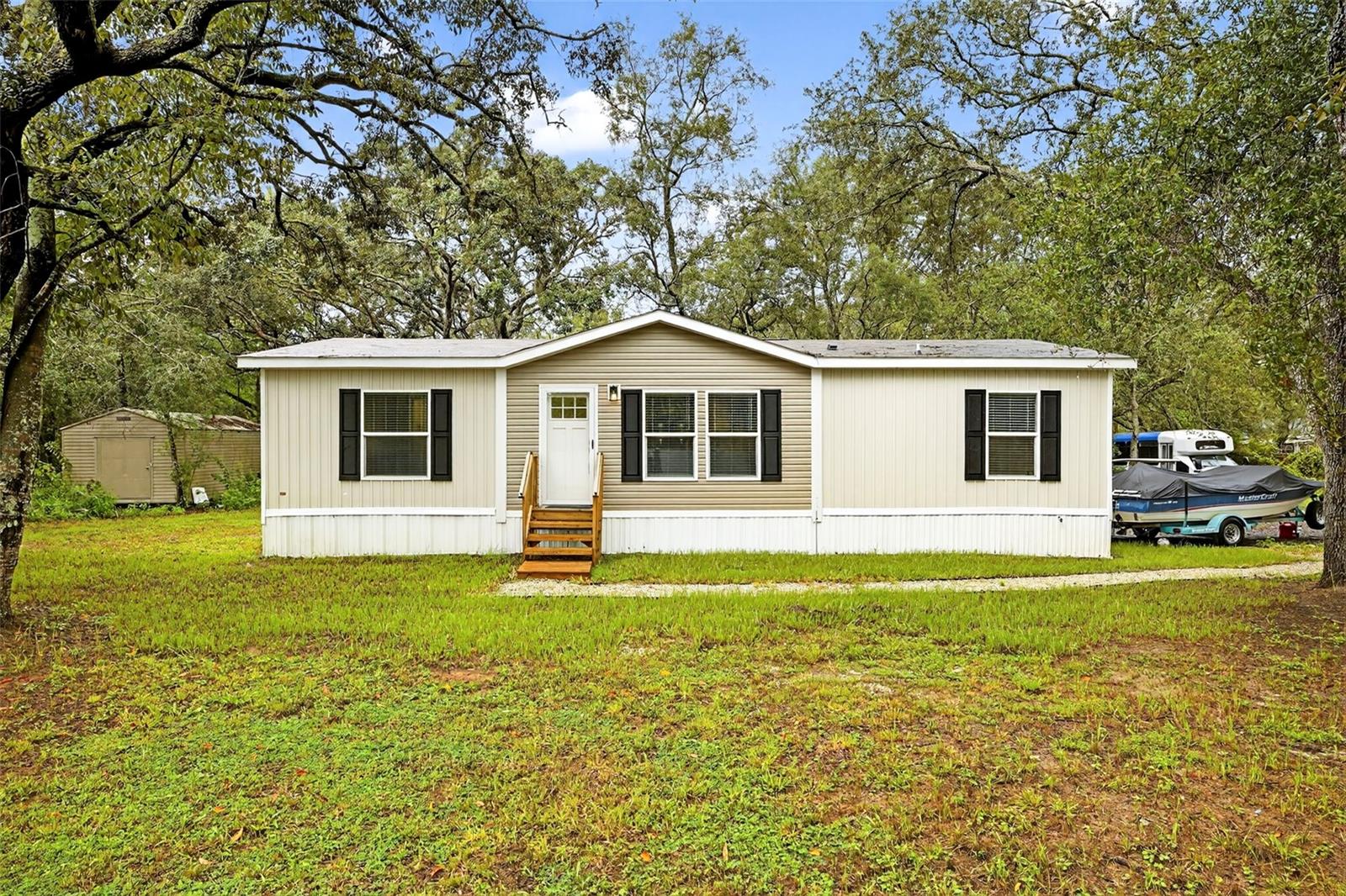 Welcome to your slice of paradise off Hayes Road – the only property in the area with striking vinyl fencing, making it truly stand out. This 1-acre lot is the perfect mix of half-cleared and half-wooded land, offering both open space and shade for privacy.
A grand 16-foot entry fence welcomes you to the property, with plenty of room for RVs, boats, and other recreational vehicles. The lot provides space for pets, outdoor activities, and family gatherings. On cool evenings, enjoy a fire under the towering shaded oaks in the back half of the property.
The home is a 2024 Clayton De Soto model featuring an open layout with luxury vinyl flooring throughout. Recessed lighting and a bright, functional design create a comfortable atmosphere. The kitchen includes an island with seating for three, stainless steel appliances, and ample cabinet space around the refrigerator and cooktop. Sliding doors open from the dining area to the backyard, perfect for indoor-outdoor living.
This residence offers three spacious bedrooms, including a primary suite with an above-average sized bedroom, bathroom with dual vanities, and a large walk-in shower. A modern laundry area with washer and dryer is also included.
This property combines the peace of country living with the comfort of a brand-new home, providing room to relax, entertain, and enjoy the outdoors.