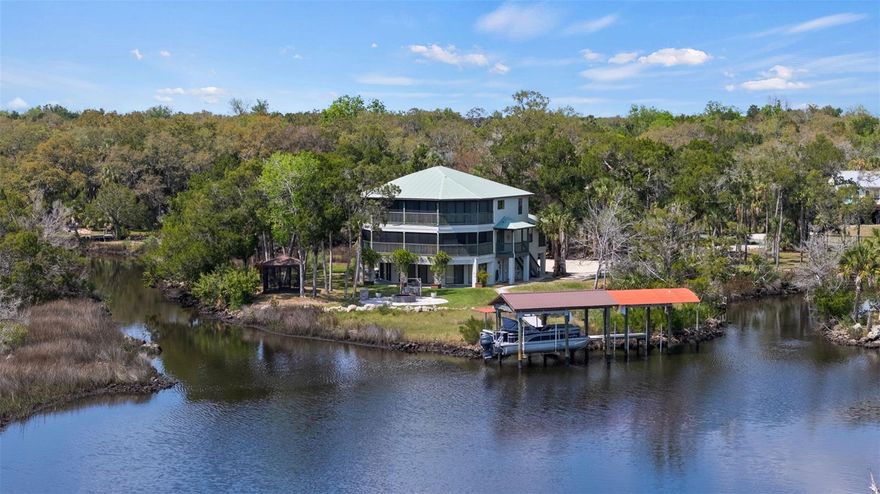 Experience the ultimate Florida lifestyle in this private, elevated 5-bedroom, 4-bathroom residence on nearly 2 acres along Mason Creek waterway. Fully remodeled in 2019, this block home offers panoramic views, direct Gulf access in 10 minutes, and is being sold fully furnished, ready for immediate enjoyment. Step inside to an open-concept first floor featuring a chef’s kitchen with quartz countertops, custom cabinetry, LG stainless steel appliances, built-in bar, and a large island, perfect for entertaining or family living. The family room boasts a stone fireplace, while three main-level bedrooms provide comfort and convenience. An elevator adds effortless access to all levels, and window treatments on every window add elegance and privacy. Upstairs, the owners’ retreat offers a private screened balcony, sitting area with fireplace, spa-inspired bathroom with freestanding soaking tub, dual vanities, and frameless shower, and a massive walk-in closet. A loft space and guest bedroom with en-suite bath provide versatility for work, study, or relaxation. Outdoors, this residence is a boater’s paradise. A lighted walkway winds through the grounds to a private dock with two covered boat lifts, a fish cleaning station and private kayak launches. Screened patios on both levels, a gazebo, and inviting fire pit make entertaining effortless. The location offers seclusion and convenience, just minutes from The Freezer, Florida Cracker Monkey Bar, and natural attractions including Chassahowitzka National Wildlife Refuge and Homosassa Springs Wildlife State Park. Enjoy world-class fishing, scalloping, kayaking with manatees, and abundant wildlife right from your backyard. This exceptional Mason Creek property is more than a home—it’s a lifestyle, combining privacy, luxury, and waterway access into a turnkey waterfront retreat on Florida’s Nature Coast. Check out the video! https://listings.tampalistinglab.com/sites/eygxdwba/unbranded