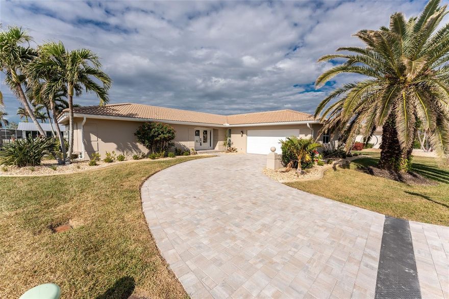 Few homes capture the essence of the Florida lifestyle quite like this exceptional 3-bedroom, 2-bath waterfront pool home in the highly sought-after boating and golf community of Punta Gorda Isles. Tucked away on a quiet cul-de-sac, this beautifully maintained residence offers the perfect blend of comfort, style, and coastal living—just minutes from historic downtown Punta Gorda and Fishermen’s Village, known for its vibrant waterfront dining, boutique shopping, and lively entertainment. From the moment you arrive, the home’s impressive curb appeal is undeniable, highlighted by a new paver driveway and lush tropical landscaping. Step through the double entry doors into a light-filled, open-concept interior where a soothing coastal palette and luxury vinyl plank flooring create an immediate sense of relaxation. Expansive views of the pool and canal enhance the seamless indoor-outdoor flow throughout the main living areas. Designed with both entertaining and everyday living in mind, the thoughtfully laid-out floor plan offers multiple gathering spaces. The kitchen serves as the heart of the home, featuring quartz countertops, stainless steel appliances, a subway tile backsplash, and a convenient pass-through bar—ideal for hosting. A charming dinette overlooks the patio and water, while a versatile bonus room provides flexible space for a family room, dining area, or additional lounge, all with beautiful waterfront views. The primary suite is a private retreat, showcasing elegant flooring, a fully renovated en-suite bath, and an adjoining bonus space perfect for a home office, sitting room, or hobby area. Guest bedrooms and bath have been tastefully updated with a relaxed coastal aesthetic, offering comfort and privacy for family and visitors alike.
Step outside to your own private oasis. Enjoy morning swims or sunset gatherings on the paver patio surrounding the heated pool, complete with electric awnings for shaded comfort. Boating enthusiasts will appreciate the 30-foot dock with a 22,500 lb boat lift, along with water and electric—providing direct access to Charlotte Harbor and the Gulf. Extensively upgraded for peace of mind, the home features a new seawall and cap, dock extension, pool heater, fencing, gutters, impact windows, added attic insulation, updated flooring, boat lift enhancements, and new entry doors. Offered fully furnished, this property is truly move-in or rent-ready. Successfully operated as a short-term rental for nearly two years, it presents an outstanding investment opportunity. For those interested, rental history, guest reviews, and a smooth transition of existing accounts may be available. Ideally located near waterfront parks, scenic biking trails, farmers markets, and year-round community events, this home offers more than just a place to live—it’s a lifestyle, an investment, and your chance to own a piece of paradise.