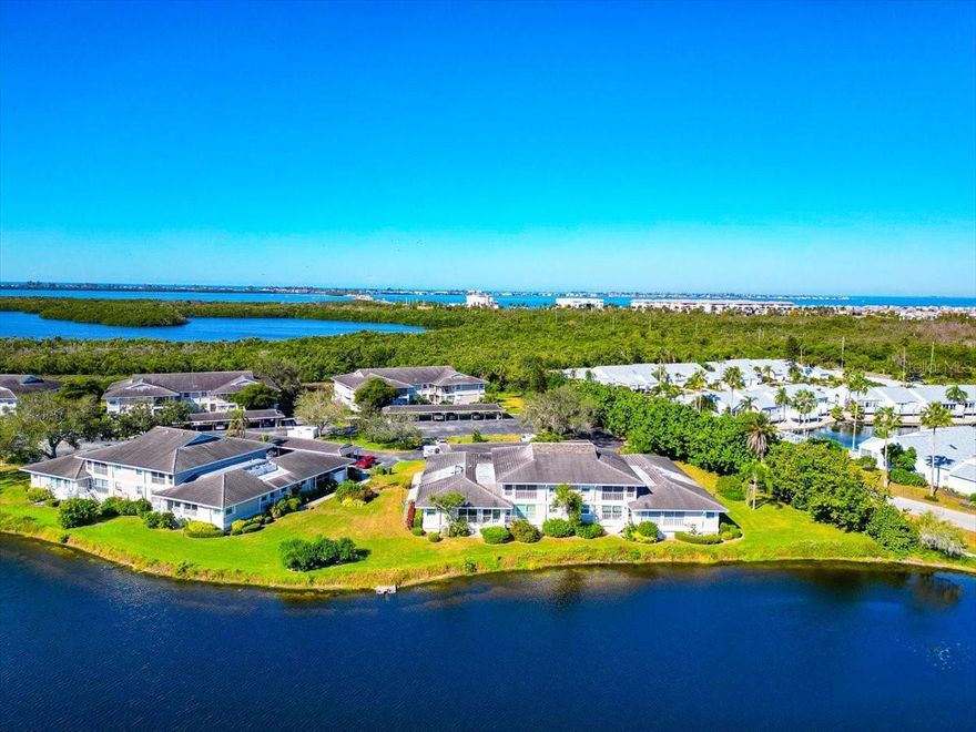 Elegantly Updated Professionally Decorated Furnished Coastal Home With Peaceful And Serene Water Views Comes Complete With WOW Factor!  You Dare Not Miss It! 
The Kitchen, Living And Dining Areas Were Opened Up By Taking Down A Dividing Wall Creating An Expansive Bright Sun Filled Open Floor Plan With Beautiful Tile Floors, Professionally Designed Chefs’ Kitchen With Built-Ins, Pull-Out Drawers, High End Stainless Appliances With Range Hood, Wine Bar, Impact Windows Throughout, Updated Interior Doors, Walk-In Closets And Plantation Shutters.  The Spectacular East Facing Water Views From Your Lanai Provides An Exquisite Peaceful Sunrise With Your First Morning Coffee. The Unique Position Of This Building Gives You The Feeling Of Being On Your Own Private Island.  With 2 Large Spacious Bedrooms & Ensuite Bathrooms, It Has Everything You Could Ever Want -AND An Electric Vehicle Charging Station Has Already Been Installed In The Carport. Sellers Spared No Expense With Upgrades. ALL Of This And More Can Be Found Behind The Gates Of Highly Sought After Perico Bay Club!  Everything’s At Your Fingertips.  You May Want to Play Tennis Or Pickleball, Kayak Out To Palma Sola Bay, Its Only Steps To The Pool Or To Join The Olympic Size Pool At The Clubhouse, Use The Exercise Room, Or Any One Of The Many Activities Or You May Want To Walk Out To The New Boardwalk For A Spectacular Sunset.  It’s A Short Walk To Both Robinson Or Neal Preserves, And A Short Bicycle Ride To The Renowned Sandy Beaches Of Anna Maria Island.  Close to Shopping & Restaurants It’s All Right Here, Ready and Waiting for You to Enjoy With Family and Friends.  Perico Bay Club Is The Lifestyle You’ve Been Looking For!! Don’t Miss This Great Opportunity, Call Today For Your Personal Tour!