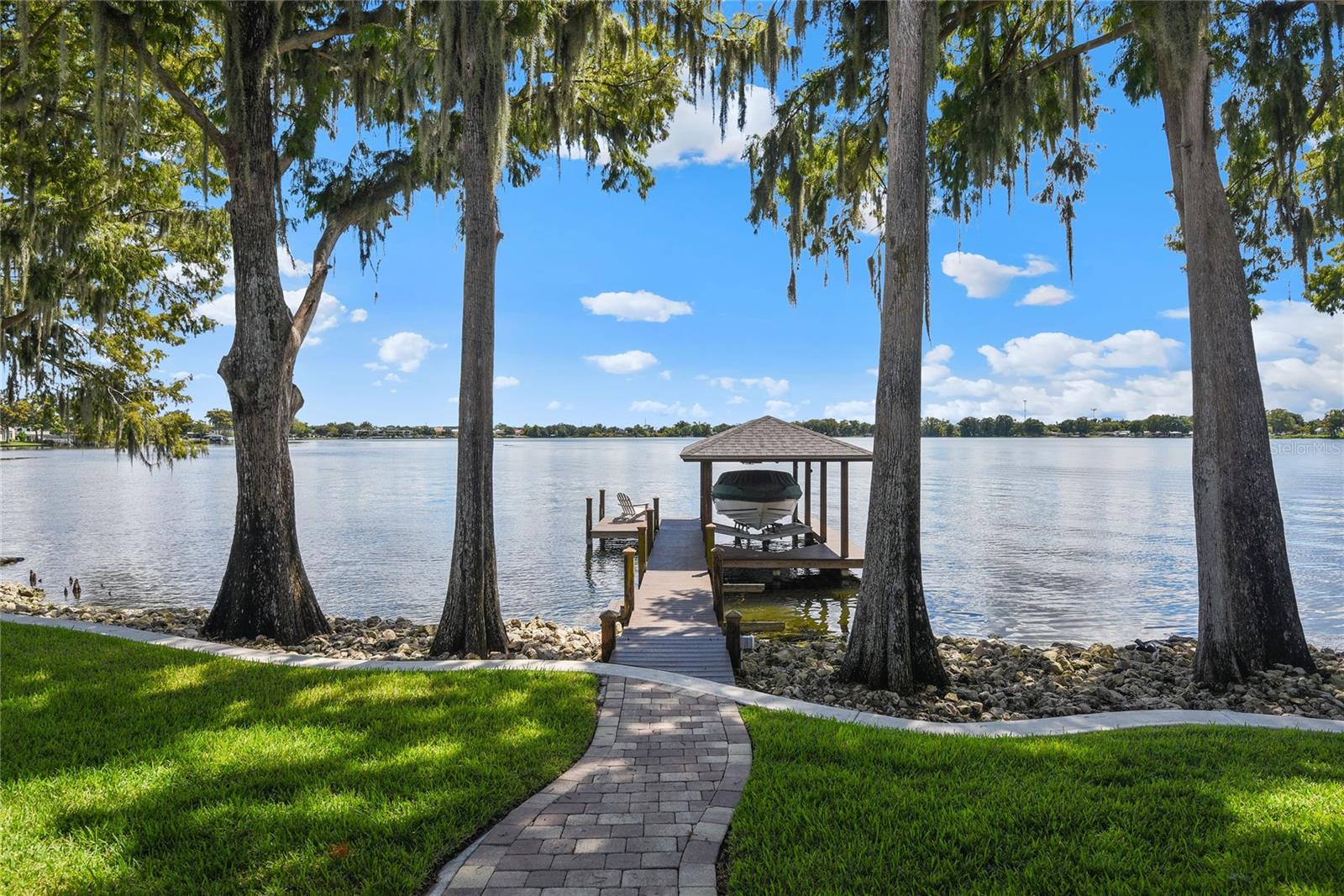 LAKEFRONT 2100 Lake Drive, Winter Park. Enjoy panoramic lakefront views from the privacy of your own home with this remarkable single-story lakefront residence on Winter Park’s private Lake Killarney. Offering an expansive 3,555 SF interior layout the home features a 4 bedroom, 3.5 bath, split-bedroom floorplan with a dedicated office. The family/great room at the back of the home has 3 sets of French doors that open to the lanai and screened pool area overlooking the tranquil waters. Off the family room is the dining room and kitchen. The chef’s kitchen is a dream space to work in: bar top peninsula, large island, deep counters, high end, stainless steel appliances, and a pass thru window. The master bedroom also sits at the back of the home taking full advantage of those water views and features two walk-in closets and an en suite bath complete with a dressing vanity. Two of the guest bedrooms are comfortably sized and share a hall bath with tub/shower combo. The fourth bedroom is larger and has its own private bath with walk in shower. There’s no shortage of outdoor living space at this home. From the covered lanai, to the pool and spa, to the covered boathouse with lift, you’ll find there are year-round opportunities to entertain friends and family at this lakefront oasis. Although this home is tucked away in a quiet neighborhood nearby shops and restaurants are just around the corner. Lake Killarney is just minutes from Park Avenue, the Winter Park Village, the Enzian, Whole Foods, and more. Additional property highlights include European Red Oak floors, recessed lighting, a wood burning fireplace, and custom built-ins. For more information on this fantastic waterfront property, inquire today!