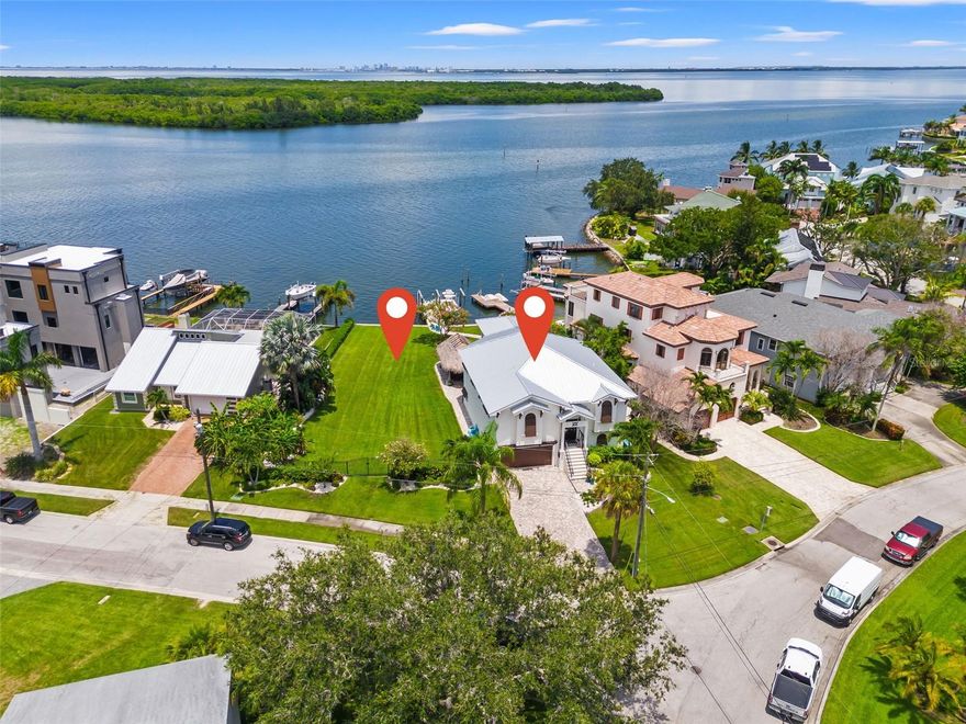 DOUBLE LOT ON OPEN WATER! Discover a unique chance to own this expansive waterfront property featuring two lots: Lot 11 & Lot 12 (1951 & 1953 ARROWHEAD DR NE) Situated on Lot 11 is a beautifully renovated home offering 2,800 sq ft of heated living space, plus an additional 500 sq ft BONUS ROOM. This impressive residence includes 4 bedrooms, 3 full baths, and a 4plus-car garage. As you step inside you will be delighted to see 10ft ceilings with gorgeous tongue & groove wood along with Board and Batten on the walls for that elegant coastal feel. The kitchen features quartzite countertops, solid wood cabinets, Stainless Steel Kitchen Aide appliances, a pantry with pull-out shelves, and an island with a cooktop overlooking the water and living areas. There are custom draperies in the living area and plantation shutters on all windows. The primary suite is rather large and has a ensuite bath with whirlpool tub, large walk in shower, dual vanities and huge walk-in closet. Elevated for added protection, the flood insurance cost is only $1,400 annually and assumable. Some of the features include a NEW standing seam roof (2023), NEW seawall (2022), NEW dock (2022), 2 NEW 10k lb. boat lifts (2022). NEW INSIDE RENOVATION COMPLETED (2021), NEW EXTERIOR & INTERIOR PAINT (2021 INT & 2023 EXT). Enjoy the spacious yard, perfect for hosting gatherings under the large TIKI HUT or on the adjacent vacant lot. The entire property has been fenced with decorative aluminum fencing that will stand the test of time. LOT 12 offers endless possibilities: develop it - build a guest house and a pool, subdivide for an additional home or income property, or simply relish in one of the largest waterfront yards on Arrowhead. With a combined area exceeding 15,000 sq ft (0.36 acres), this property represents a dream opportunity for waterfront living. Imagine living on the water with amazing sunrises and sunsets everyday!