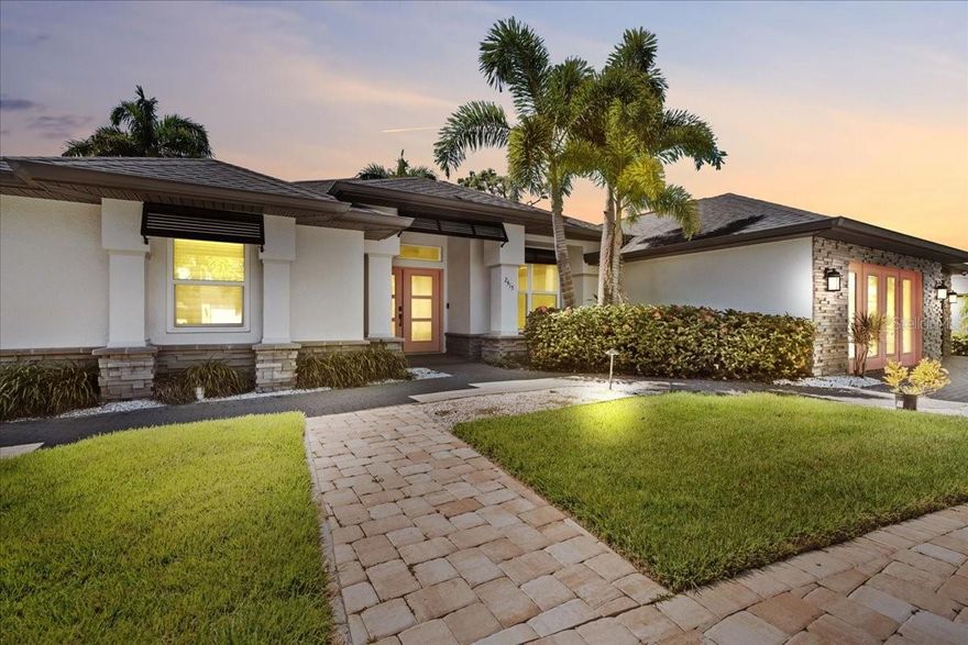 Step into luxury with this custom home built in 2018 by Walker Homes, offering 2,286 square feet of beautifully finished living space on an oversized half-acre lot in the heart of North Port. Featuring three bedrooms and two and a half baths, this thoughtfully designed residence boasts a split-bedroom layout with a spacious main-level primary suite, offering the perfect combination of comfort and privacy. The gourmet kitchen is a chef’s dream, highlighted by a striking waterfall island, custom cabinetry, stainless steel appliances, and high-end finishes throughout. The open-concept living space features coffered ceilings and is bathed in natural light, with durable luxury vinyl plank flooring throughout the main living areas and luxury tile in the bathrooms for a modern, cohesive feel. A bonus room off the main living area provides additional flexible space—ideal for a home office, playroom, den, or guest area—and includes extra built-in storage with endless potential to fit your lifestyle needs. Step outside into your private tropical retreat. Take a dip in the in-ground pool, grill under the expansive covered lanai with built-in summer kitchen or unwind beneath the brand-new patio pergola. A charming tiki hut adds a touch of island living—perfect for entertaining or simply relaxing in the shade. The lush landscaping is supported by an irrigation well system and enhanced by solar lighting, creating a tranquil, resort-style setting. The home also includes a finished RV port/garage wing with its own private entrance, workshop, office space, and half bath—perfect for guests, hobbies, or extended workspace. With plenty of parking for RVs, boats, or extra vehicles and no HOA or CDD fees, this home offers flexibility and freedom rarely found in a custom property.