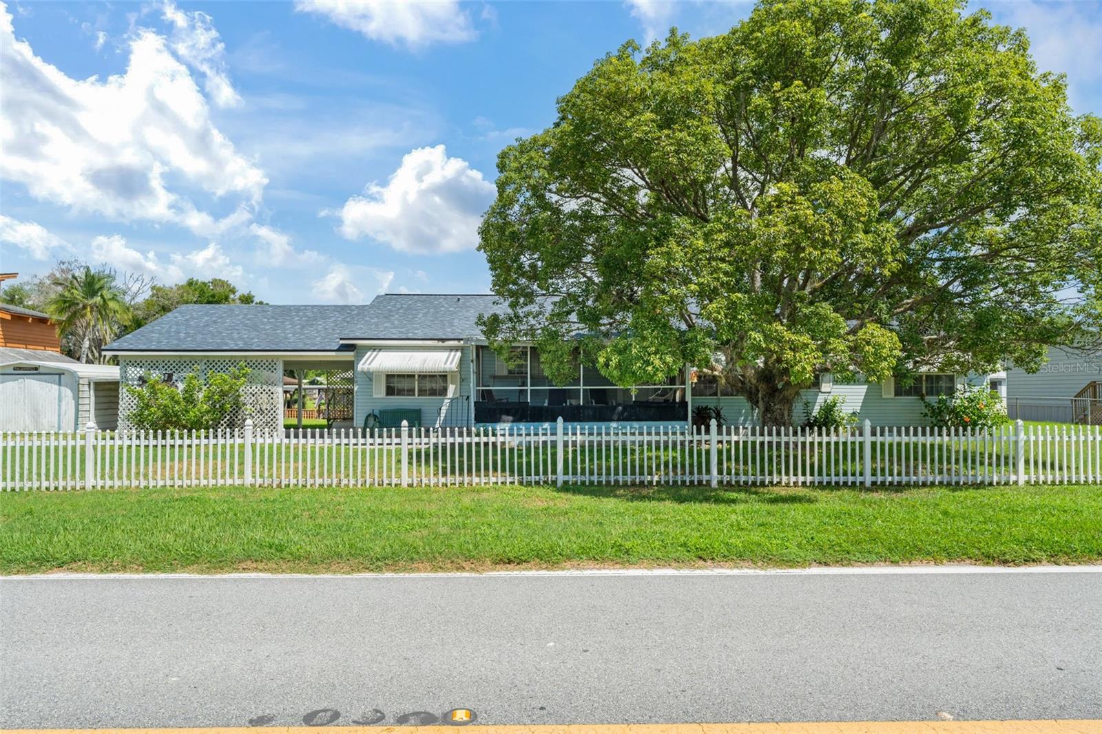 **This property qualifies for a closing cost credit up to $4,600 through the Seller’s preferred lender.** Welcome Home to Your Waterfront Retreat! Nestled behind a charming white picket fence, this delightful 3-bedroom, 2-bathroom single-family home is full of warmth, character, and Florida charm. Located in peaceful Haines City, this home offers the perfect blend of cozy living and outdoor adventure—complete with your very own private boat house and ramp with access to a canal that leads to the beautiful Lake Hatchineha. Step onto the screened-in front porch, a serene spot to sip your morning coffee or unwind at sunset while enjoying the tranquil views. Inside, you’re welcomed by a bright and open living and dining room combo, featuring a wood-burning fireplace and French doors that open to your screened-in pool and patio—ideal for entertaining or simply relaxing in your own backyard haven. The kitchen is both functional and charming, with off-white cabinets, black appliances, and a quaint breakfast nook perfect for casual meals. Conveniently located nearby is the laundry closet with direct access to the spacious two-car carport. This thoughtful split-bedroom layout offers privacy and comfort. The primary suite, located just off the kitchen (perfect for late-night snack runs!), boasts both a built-in and walk-in closet, ensuite bathroom with soaking tub and separate glass-enclosed shower, and private access to the pool and patio. Across the home, you’ll find two additional bedrooms and a full bathroom with a tub/shower combo—ideal for family or guests. Step outside and you’re greeted with views of the peaceful canal, your private boathouse, and fish cleaning station—an angler's dream. This canal not only leads to Lake Hatchineha, but also connects to a chain of waterways that can eventually take you all the way to both the Atlantic Ocean and the Gulf of Mexico—offering endless possibilities for boating adventures. Whether you're boating, fishing, or just enjoying the gentle breeze off the water, this outdoor space has it all. The pool offers a blank canvas to create your own backyard oasis, complete with room to garden or play in the grassy area near the boathouse. With two storage sheds, a covered carport, and direct access to Lake Hatchineha, this home is more than a property—it's a lifestyle. Come experience the peace, charm, and waterfront magic of 13958 Hatchineha Rd. Welcome home.