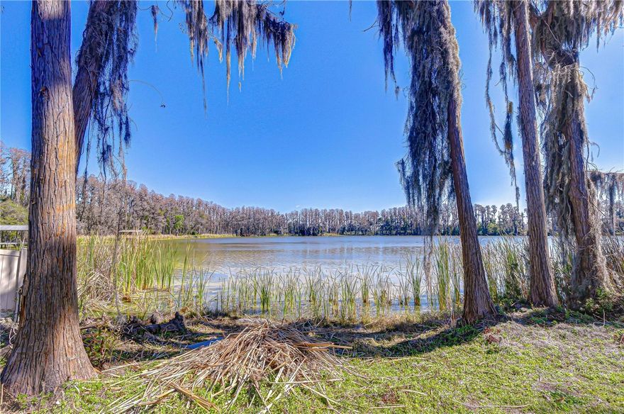 Opportunity to own 3 private acres on beautiful Wisteria Lake in the heart of Land O’ Lakes. Wisteria Lake spans approximately 23.76 acres and features a sandy white bottom, ideal for skiing, kayaking, or simply relaxing and enjoying the waterfront lifestyle. The property offers approximately 228 feet of road frontage and 160 feet of lake frontage, providing ample space to add a dock, deck, or expand your outdoor living area. The home is a solid block construction featuring 3 bedrooms and 2 bathrooms in the house, a 3rd bath is in the garage area added on. A separate freestanding block garage offers approximately 1,947 square feet (approximately 30’ x 65’) with openings on both ends — perfect for storage, workshop space, boats, recreational vehicles, or hobby use. An additional shed provides convenient storage for outdoor tools and equipment. No HOA or deed restrictions. Conveniently located just minutes from shopping, dining, and schools, with easy access to the Veterans Expressway/Suncoast Parkway for commuting to Tampa, St. Petersburg, Clearwater, Dunedin, and Tarpon Springs — enjoy everything Florida’s west coast communities have to offer.