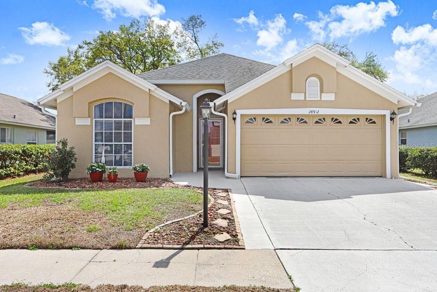 Are you looking for turn-key, move-in ready and meticulously cared for?? Then schedule your showing today, because this 3-bedroom, 2 bath home is sure to impress!  This gem is located in a prime area less than a mile to i-75 in The Villages of Wesley Chapel.   The 11 ft vaulted ceilings in the family room and different height variations throughout make this home feel open and airy.  Upon entering you will have 2 bedrooms upfront with nicely sized closets and a full bathroom featuring a shower tub combo.  The primary bedroom is located to the rear of the home giving a nice separation of space with high ceilings and 3 windows across the rear allowing tons of natural light. You will find beautiful engineered hardwood floors throughout the entire home with tile in the wet areas.  That's right, not a lick of carpet in this home.  The kitchen has been tastefully upgraded with solid maple cabinets and quartz countertops, slate stainless steel appliances and a microwave that is vented to the exterior. The cafe space is rather large and holds a nicely sized round table.  The current owner has the dining room set up as a home office but floor to ceiling mirrors gives a nice formal feel along with skylights high above.  The A/C, roof & water heater were replaced in 2017 along with new exterior paint. Other upgrades include new vanities & toilets in both bathrooms, ceiling fans & light fixtures, front door, side garage door, fencing, front load washer & dryer (that will convey), water softener w/ultraviolet-sanitaire, and interlocking decking on lanai.  And best of all, NO CDD in this community just a super low HOA of $370 per year!! You are less than 2 minutes to Publix, multiple dining options, the new Baycare Hospital, the Krates and so much more.  Don't snooze on this beauty!!! (A/C serviced and cleaned 7/25 along with dryer vent maintenance).