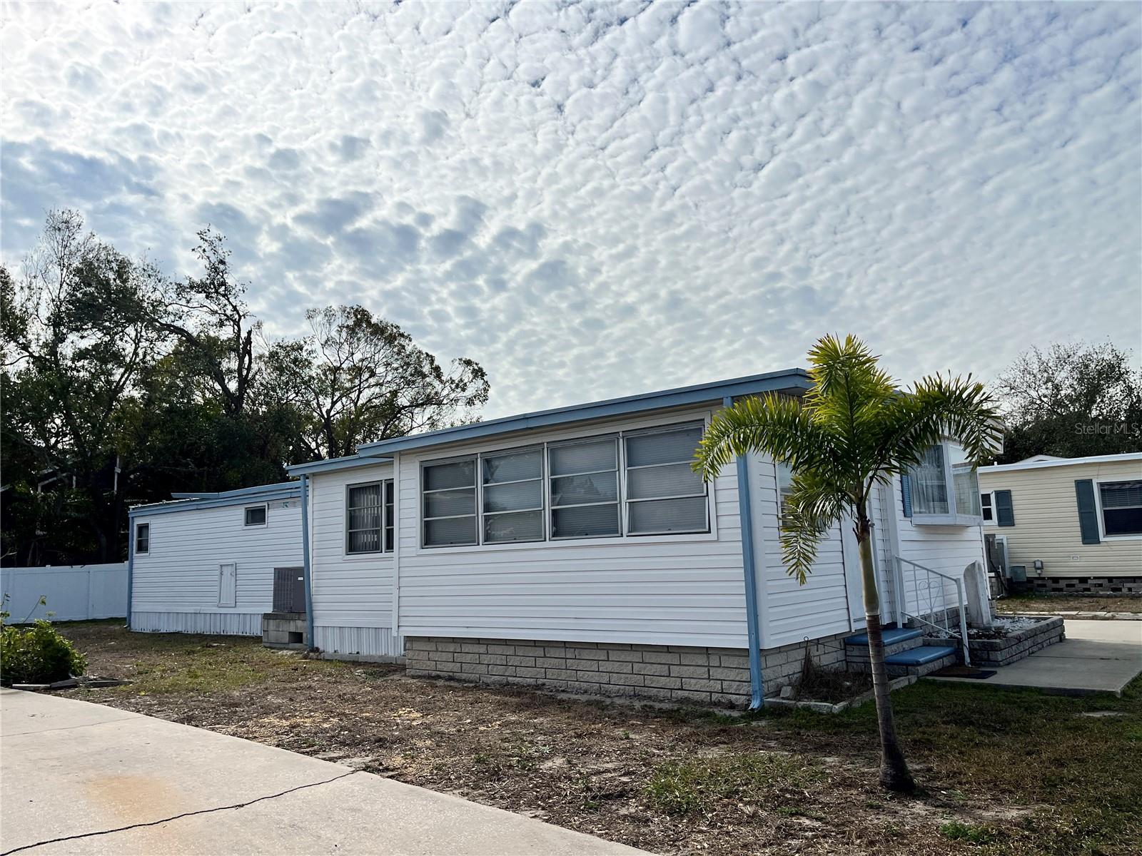 This 2 bedroom 1 bath home with an enclosed porch is a handy man special or the old home can be taken out and a stilt home placed on the lot. Home is on a good size lot. The home has sustained damage from Hurricanes Helene and Milton.
Home is located in Americana Cove, a 55+, resident owned, waterfront community only 10 minutes from downtown St Pete, 20 minutes from two airports and 25 minutes to Gulf beaches. Low monthly fee of $380 includes 24 hour manned gate, private streets, water/sewer, lawn mowing/edging, trash pick up twice weekly and all amenities including heated pool, shuffleboard, bocce ball, two boat ramps and kayak launch. And many clubs and activities to get involved in. Price includes share for the lot and ownership in the co-op.