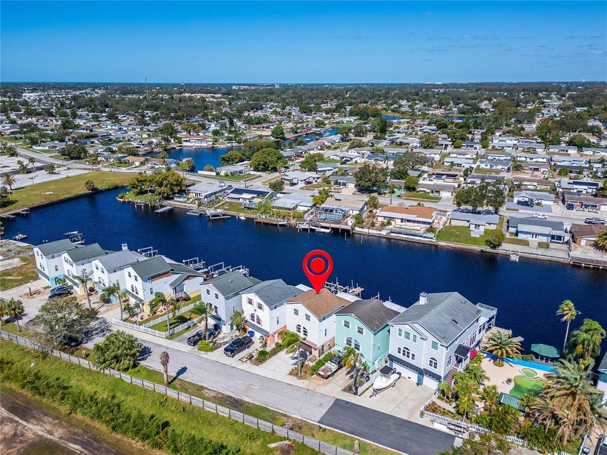 Welcome to 5311 Boardwalk St, a rare opportunity to own a beautifully updated waterfront townhouse in the desirable Park Place subdivision, offering NO HOA and NO CDD fees. Built in 1998 and featuring approximately 1,848 square feet with 3 bedrooms and 2.5 to 3 bathrooms, this home combines modern upgrades with exceptional riverfront living. Immaculately maintained and thoughtfully upgraded, the residence sits along the serene Anclote River, providing direct water access and a private dock, perfect for boating enthusiasts with easy access to the Gulf of Mexico. Inside, soaring cathedral ceilings and an open concept layout fill the home with natural light while showcasing tranquil water views. The kitchen has been tastefully updated with high end cabinetry, stainless steel appliances, and elegant quartz countertops, creating a sleek and functional space for everyday living and entertaining. Bathrooms have been fully modernized with frameless glass showers, subway tile, quartz accents, and stylish vessel sinks, delivering a spa like experience throughout. Impact resistant windows and sliders enhance both safety and energy efficiency, while beautiful eucalyptus wood flooring flows seamlessly through the main living areas, adding warmth and durability. The spacious oversized garage offers ample storage, adding convenience and practicality. The owner’s suite serves as a private retreat, complete with a well appointed en suite bathroom and a generous California style walk in closet. Additional bedrooms are thoughtfully designed and connected by a Jack and Jill bathroom, ideal for family or guests. Offered with the option to include tasteful furnishings, this move in ready waterfront home is the perfect blend of luxury, comfort, and coastal lifestyle. Experience the best of Florida living where modern sophistication meets peaceful riverfront serenity.