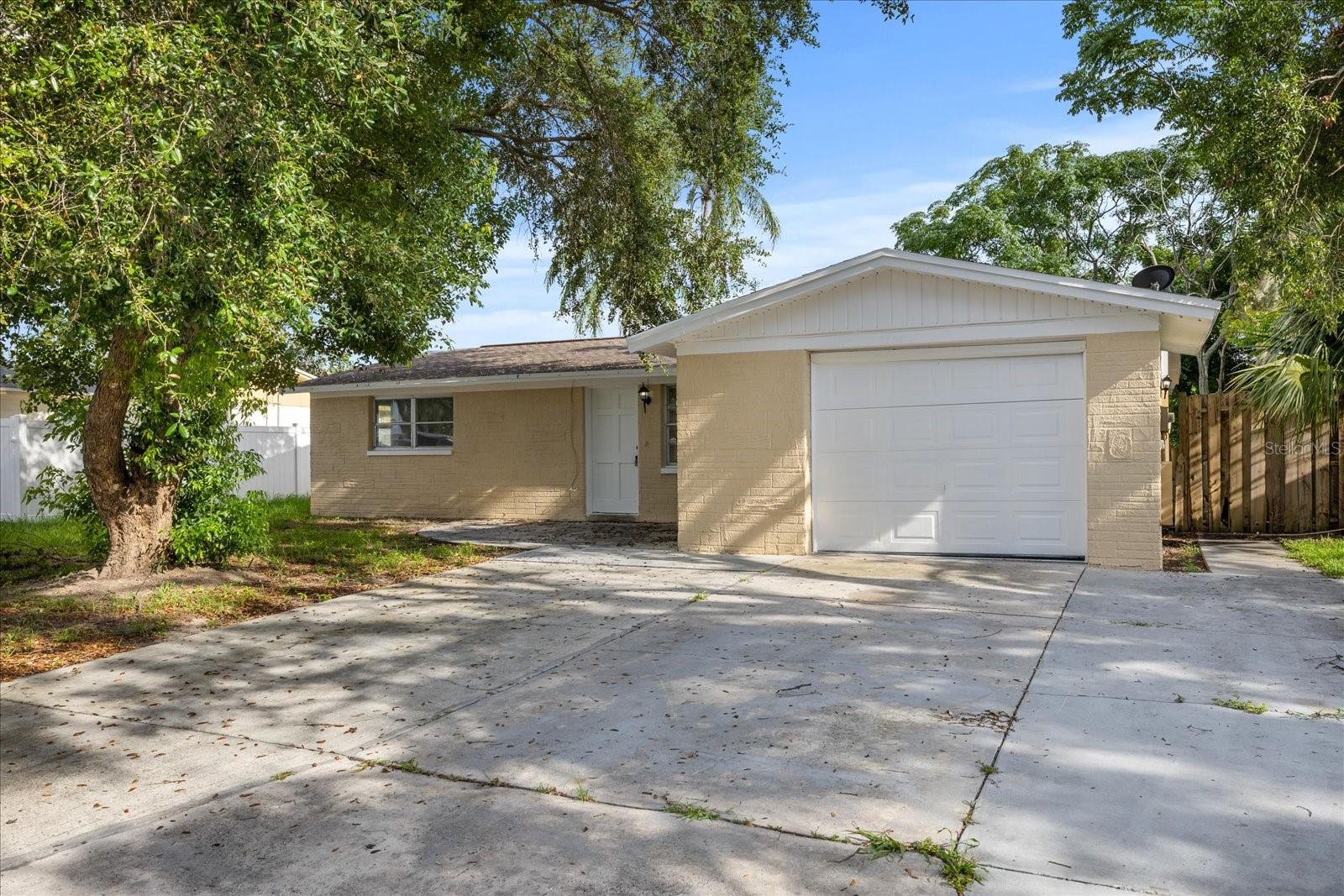Discover your next opportunity in this charming 4 bed / 2 bath home in Holiday’s Aloha Gardens! With 1,226?sqft of bright, open living space, this single-story residence boasts abundant natural light, thanks to large windows and ceramic tile floors throughout. Stove, fridge, and a handy microwave included. Both bathrooms have been refreshed with contemporary vanities, fixtures, and mirrors. The layout includes generously sized bedrooms and a convenient 1-car attached garage.
Step outside to a spacious backyard perfect for barbecues, gardening, or relaxed outdoor enjoyment. Nestled in a quiet neighborhood near US-19, this home provides easy access to local parks, shopping, dining, and the area’s beautiful beaches like Fred Howard Park and the Tarpon Springs Sponge Docks