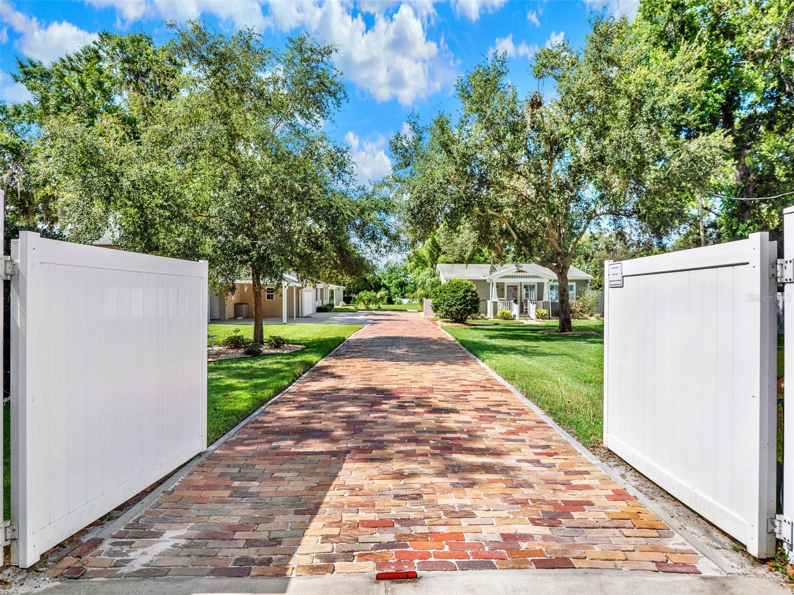 Private Family Compound with Multiple Buildings. Car Enthusiast’s Dream! Income Potential. No HOA. Welcome to Your Private Oasis Overlooking the Serene Waters of Lake Saunders. This Unique Multi-Building Family Compound Offers Endless Possibilities with Three Distinct Structures: a Spacious Single Family Home, a Charming Guest Cottage, and a Fully Equipped Man Cave, Perfect for Hobbyists or Additional Entertaining Space. From the moment you Pass Through the Private Gated Entrance, you’ll Appreciate the Attention to Detail and thoughtful Upgrades Throughout the Property. The Main Residence Features Spray Foam Insulation for Year Round Energy Efficiency, and a 22kw Whole House Generator Offers Peace of Mind no matter the Weather. Relax in the Screened Lanai, Gather around the Gas Fire Pit, or Entertain on well Manicured Lawns and Greenspace. The reclaimed Chicago Brick Pavered Driveway adds to the Charm. Car enthusiasts will be Thrilled with the Expansive Garage and Workshop both Climate Controlled with HVAC and also with Spray Foam Insulation, Additional Covered Parking or Carport, and plenty of Space to Store and Tinker with their Collection. Whether you're a Collector, Craftsman, or Someone who just needs space, this Setup Delivers. The Guest Cottage Provides a Perfect Opportunity for Income Producing Rental, a Comfortable Space for Extended Family or In-Laws, or a Private Retreat for Guests. For the Golf lover in the Family, the Custom Putting Green Offers a Place to Sharpen your Short Game, who knows, you could be the next U.S. Open champion in the making! With NO HOA restrictions, you have the Freedom to Truly make this Property your own. Whether you're looking for Multi Generational Living, a Home Based Business Hub, or a Car Collector’s Paradise, this One-of-a-Kind Property is ready to fit your Lifestyle. The Possibilities are Endless in this Rare and Private Florida gem.