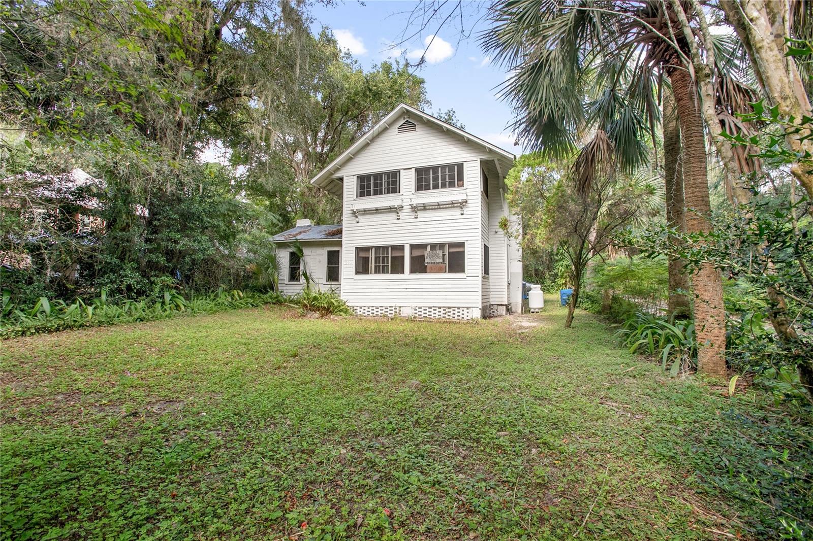 This delightful 2-story residence, built in 1945, perfectly blends vintage charm with local history. Nestled on just under a half-acre of lush, mature landscaping, this property boasts well-established trees that provide a serene, shaded retreat. Step inside to discover beautiful wood floors that add warmth and character throughout the home. The spacious layout offers plenty of room for relaxation and entertainment, with ample natural light streaming in from above. Located just a stone's throw away from Cassadaga, you'll enjoy the convenience of nearby amenities while savoring the tranquility of Lake Helen. Plus, this home is not in a flood zone, giving you peace of mind. Don’t miss the opportunity to own this unique gem in a picturesque setting. Schedule your showing today and experience the charm of this lovely Lake Helen home!