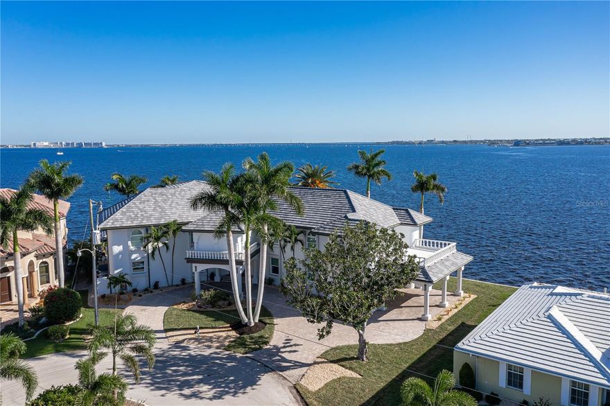ONE-OF-A-KIND, THREE-STORY, HARBORFRONT HOME W/234 FT OF SEAWALL, UNSURPASSED HARBOR VIEWS, ELEVATOR, EXTENDED CONCRETE DOCK & NEW ROOF (2023) - Exceptional, 6300+ sqft, 4 bed/4 full & 2 half bath, waterfront home in Punta Gorda Isles is truly a showcase property w/gorgeous two-story entry that features a spiral staircase, sunken formal living room & large picture windows allowing you to enjoy the beauty of the harbor views from almost every room. Home is designed for entertaining & boasts a private wine "cellar" & home theater. The large formal dining room is designed for creating memories with friends & family. The kitchen was completely renovated in 2020 & DOES NOT DISSAPPOINT! Kitchen offers granite counters including a large center island w/breakfast seating at the rounded peninsula, custom cabinetry, two full sinks & top-of-the-line stainless steel appliances including a 6-burner gas Wolf range w/built-in grill & griddle, Wolf convection/steam oven w/separate warming drawer, Cove dishwasher, 72in side by side SubZero refrigerator/freezer & SubZero wine refrigerator. Two pantries including a large walk-in pantry w/motion-sensor lights complete the kitchen. A large breakfast area w/mitered aquarium bay window is located just off the kitchen. A large bedroom (den) w/built-in bookshelves, en-suite bath & large walk-in closet completes the first floor. Access the 2nd floor by elevator or the large winding staircase in the foyer. Here, you'll discover the game room w/full bar & adjacent reading nook, home theater plus the owners' suite & two large guest bedrooms as well as the oversized laundry room. The game room has a full pool table w/ping pong tabletop that will stay with the home. The owners' suite has a wall of sliding glass doors leading to the private balcony overlooking the breathtaking views. Spa-like bath is spacious featuring dual sinks on split vanities, a modern soaking tub & tiled walk-in shower. A home gym/bonus room is located between the bathroom & walk-in closet/dressing room of the owners' suite. Owners' dressing room/walk-in closet is cedar-lined & features built-in shelving maximizing the storage here. The two, large guest rooms offer en-suite bathrooms & large walk-in closets. A spiral staircase leads to the 3rd floor bonus room/crow's nest that features another private balcony offering unparalleled views from the lofty vantage point. Outside, the home has a LARGE lanai w/summer kitchen, half bath, NEW brick paver decking surrounding the in-ground, heated pool & attached spa. Pool has electric heat pump & spa is heated by propane. Home has FULL HURRICANE PROTECTION w/impact windows AND roll down shutters for most openings (accordion shutters on aquarium bay window at breakfast area). Oversized, side entry garage has tons of extra space including a bump out that can be used as a workshop or extra storage. Other amenities include FOUR A/C systems, two dehumidifiers, two tandem 80-gal hot water heaters w/recirculating pump, whole-house water softener, two RO systems (kitchen/upstairs bar), 80amp Tesla/EV charging station in garage, & mostly LED lighting w/exception of chandeliers in foyer & dining room. Recent updates include ALL NEW modern landscaping -front & back - including new sod (2023), NEW carpet (2023), NEW ROOF, NEW impact-resistant windows, fresh exterior paint (2023), new pavers surrounding on lanai (2023) & NEW PEX water lines (2020). Make appointment today - DISCOVER YOUR PLACE IN PARADISE TODAY!
