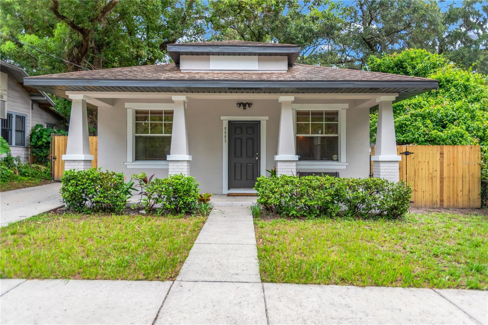 Welcome to this charming Tampa bungalow. It is a beautiful move-in ready 3-bedroom, 2-bathroom home nestled on a quiet street in the heart of Tampa. This property seamlessly blends classic Florida character with modern comforts, offering the perfect space for families, first-time homebuyers, or investors. Upon arrival you will love the new exterior paint and fencing and the welcoming curb appeal. Step inside to discover an open-concept living and dining area filled with natural light and neutral tones, creating a warm and inviting atmosphere. The updated kitchen features sleek countertops and plenty of cabinetry for storage – ideal for home cooks and entertainers alike. A convenient breakfast bar with pendant lighting and a dinette area that are directly off the kitchen. The primary suite includes a private en-suite bathroom, while two additional bedrooms provide flexibility for guests, a home office, or growing families. One of the standout features of this home is the bright and airy 11x9 sunroom – perfect for a reading nook, playroom or indoor garden. Overlooking the backyard, it adds valuable bonus space and charm to the home.
Enjoy Florida living at its best in the spacious, fully fenced backyard and newer shed. Perfect for pets, gardening, or weekend BBQs. With mature trees and plenty of room to relax or play, it’s a true outdoor retreat. Other highlights include: AC replaced in 2022, an inside laundry area and No HOA or CDD fees. This home is less than a block away from the Hillsborough River and the Mann-Wagnon Memorial Park. Located just minutes from downtown Tampa, Seminole Heights, major highways and entertainment options, this home offers both convenience and comfort. Schedule your private showing today and make this delightful property your next home!