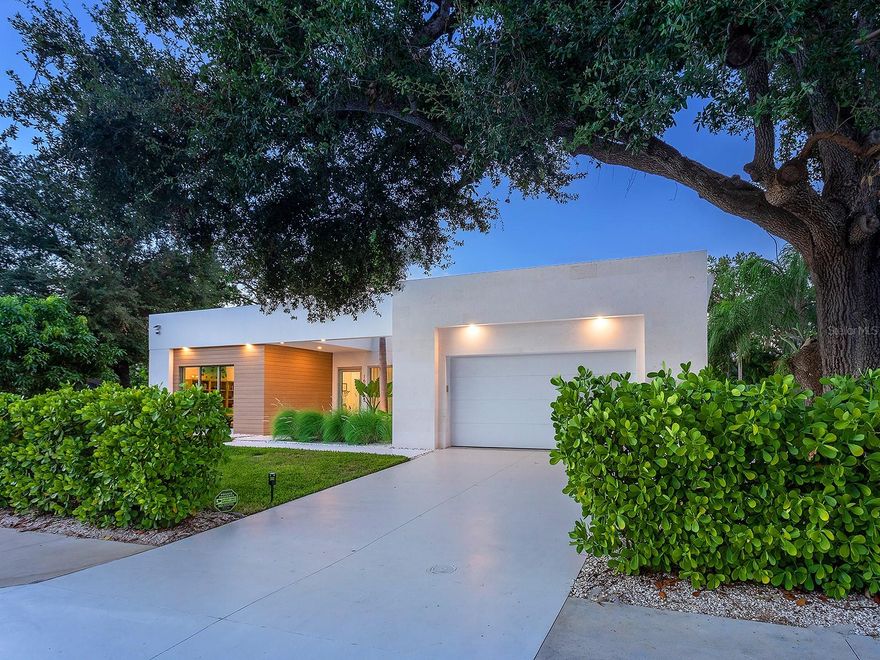 Tucked quietly West of the Trail, just steps from Southside Village, this 2023 custom-built residence blends architectural precision with effortless Sarasota living. Every line, material, and light-filled space reflects intentional design for those who value modern form, privacy, and connection. Behind its limestone and engineered wood facade, the home unfolds in a gallery-like flow of clean lines and calm tones. Inside, the welcoming foyer with its walls of glass leads to the open-concept great room that anchors the home, a space of volume, natural light, complete with multiple seating areas and custom-designed built-ins. Walls of oversized impact glass sliders blur the boundary between interior and exterior, opening to a lushly landscaped sanctuary centered on a smart-controlled pool and spa with a waterfall feature, see-through gas fireplace, and lounging areas framed by tropical greenery. With its cantilevered wood ceiling, remote-controlled awnings and custom lighting, the outdoor spaces are designed for effortless enjoyment, where modern design meets everyday comfort. Blending sleek contemporary design with chef-level performance, the custom kitchen is as beautiful as it is functional, featuring custom Cucine Ricci walnut cabinetry, Moderno Porcelain Works backsplash, and a suite of Miele appliances, including a 6-burner gas stove, Micro/Convection Speed Oven, and Electric Convection Oven. Completing the ensemble are Liebherr Monolith refrigerator and freezer columns, Bosch dual dishwashers, and a 106-bottle dual-zone wine cooler with LED illumination and smart temperature modes.  The primary suite, located poolside for ultimate privacy, embodies spa-like serenity. Porcelain slab walls, Grohe and HansGrohe fixtures, a Toto smart commode, and Cucine Ricci vanities define the bath, while a Closets Envy custom walk-in closet and retractable privacy screens add tailored sophistication. The versatile office, accessible through a private street entrance, offers the flexibility today’s lifestyle demands—perfect as a home workspace, guest suite, or professional studio. Its thoughtful design allows for easy enclosure to create a fully private, self-contained retreat, complete with a custom Closets Envy wardrobe and ensuite bath showcasing porcelain finishes, Cucine Ricci cabinetry, and high-end fixtures. Two additional guest bedrooms are equally well appointed, each featuring Closets Envy built-ins and abundant natural light. They share a spacious Jack & Jill bathroom with Cucine Ricci cabinetry, porcelain walls, and designer fixtures, complemented by a large-format tile backsplash that extends throughout, creating a cohesive, elevated aesthetic. Throughout the home, fully integrated smart systems manage lighting, climate, security, shading, and irrigation with ease. 48x48 Brazilian porcelain tile flooring, Lutron smart-controlled lighting, and dual-zone Ecobee thermostats ensure seamless comfort and consistency. The two-car garage, clad in matching limestone, includes app-based controls, an integrated camera, and a 220 line for EV charging. Every element of 1631 Hillview Street is crafted to simplify life and elevate every moment—whether entertaining, working from home, or unwinding in quiet privacy. Perfectly situated near Southside Village, downtown Sarasota, and the Gulf beaches, this home captures the essence of refined, effortless modern living.