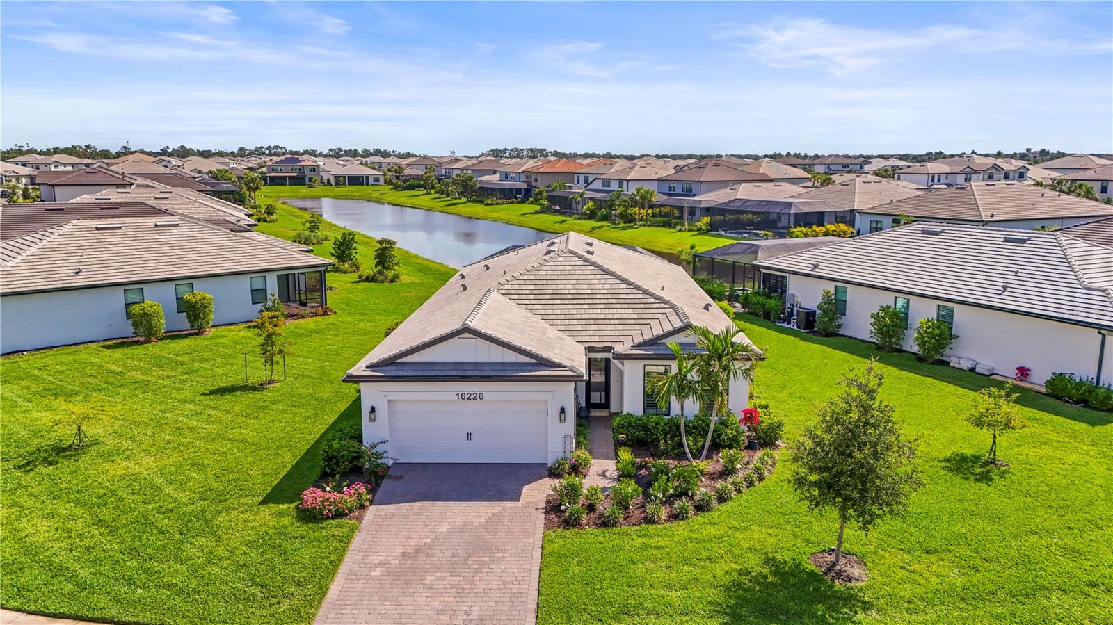 Welcome to your custom dream home in the exclusive, gated enclave of Sapphire Point at Lakewood Ranch—where luxury living meets resort-style serenity . Perfectly positioned on the largest lot in the community, this exceptional residence, with over $130,000 in upgrades, boasts commanding curb appeal with an elegant paver driveway and breathtaking water views. Every detail has been thoughtfully designed to create a private retreat unlike any other. Step into your personal outdoor oasis, where a custom saltwater heated pool awaits—complete with deck jets, therapy jets, bubblers, and a fully customizable LED lighting package for unforgettable evenings under the stars. Inside, the home is equally impressive with wood-style tile flooring throughout, plantation shutters, and a light-filled open-concept layout. Expansive pocketing corner sliders effortlessly dissolve the boundary between indoors and out, creating seamless indoor-outdoor living. At the heart of the home, the gourmet kitchen is a chef’s dream—featuring premium stainless steel appliances, a KitchenAid refrigerator, and extensive custom cabinetry with integrated built-ins, pull-out drawers, and clever smart storage solutions. The walk-in pantry is a showstopper, boasting additional built-ins to keep everything beautifully organized. The spacious primary suite is a true sanctuary, with dual vanities, a soaking tub, walk-in shower, and a generously sized custom closet. Additional highlights include a custom-designed laundry room, garage with overhead storage, and pre-wiring for two EV charging stations—future-ready and fully equipped for modern living. This is your chance to own a truly one-of-a-kind home in one of Lakewood Ranch’s most coveted neighborhoods. Don’t miss it—your dream lifestyle starts here.