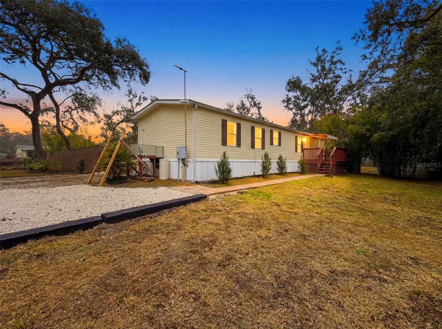 HUGE PRICE IMPROVEMENT! Move-in ready 2-bedroom, 2-bath manufactured home, built in 2012, situated on 1.14 acres of peaceful country living with NO HOA and NO LOT RENT—yet conveniently close to town!  Bring your RV, as the property is equipped with 50-AMP electric, water hookup, and an RV canopy.  This IMMACULATE HOME offers an open floor plan, lots of cabinets, crown molding, stainless appliances and is being sold FULLY FURNISHED, including the washer and dryer.  Additional upgrades include a WATER SOFTENER, GUTTERS, and an AWNING OVER THE FRONT PORCH.  The FULLY FENCED PROPERTY with GATED ACCESS offers exceptional privacy, with the BACKYARD COMPLETELY SECLUDED by an extended-height fence.  Enjoy your own private outdoor retreat featuring a SPA and HEATED OUTDOOR SHOWER, FIRE PIT with SEATING AREA, 2020 STORAGE SHED, plus additional storage.  Ideally located just a short drive to Disney, Universal Studios, Busch Gardens, Lowry Park Zoo, Hard Rock Casino, 4 international airports and Florida’s beautiful beaches!  A rare find—schedule your showing today!