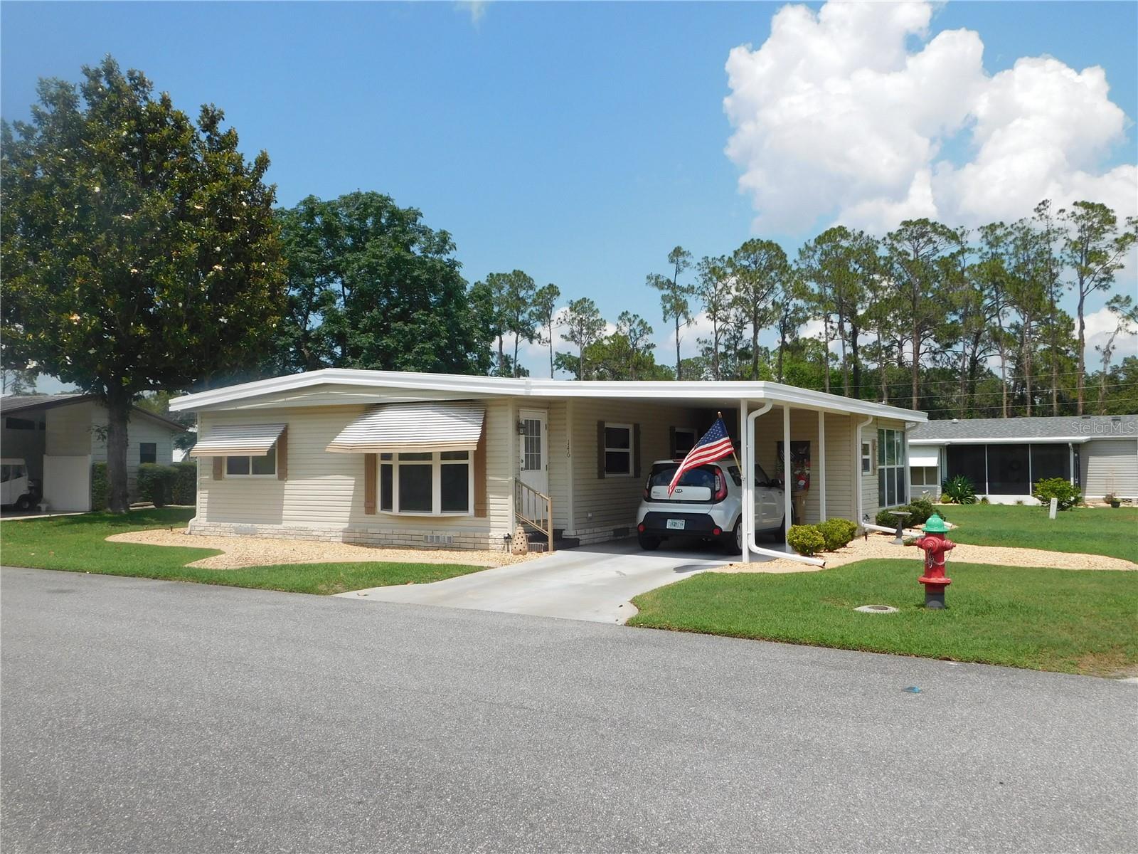 You will love this immaculate 2-bedroom, 2-bath home. The large, manicured corner lot, with plenty of backyard space, and shutters and awnings all around the exterior, makes this a very appealing property.
The living and dining room combo has a bump-out floor-to-ceiling window for added interest. Bedrooms offer walk-in closets. Bedrooms, living room, & dining room are carpeted. The kitchen features updated white cabinets, white appliances, ample storage space, & vinyl flooring. The washer & dryer are inside the house, outside utility room has a laundry tub, Enjoy the spacious, enclosed Florida room, complete with ceramic tile & air conditioning.
AC was replaced in 2020, ensuring a comfortable living environment. The property also features updated white vinyl windows & a roof over, providing a sense of security regarding the property's condition. Hawthorne at Leesburg is a private, gated 55+ community that offers everything to keep you entertained, without the congestion often found in other communities. You can be busy every day of the week or relax at the pool. Amenities Included in Your Maintenance Fee: Hawthorne’s courtesy bus will pick you up & drop you off right at your door for weekly trips to stores, banks, and malls. Fitness room available Library on site Wi-Fi available in our spacious club house Garden plots available for residents to grow vegetables & flowers Storage area for boats, recreational vehicles & trailers Outdoor geo-thermally heated swimming pool & two enclosed therapeutic pools Men’s & women’s sauna Twenty-four (24) tournament class, lighted shuffleboard courts affiliated with the Florida Shuffleboard Association Northern District. Four tennis courts (two lighted), three pickleball courts. They also have four bocce courts, a Softball field (for men’s & women’s teams), a Putting area, & an 18-hole pitch & putt course. There are two dragon boats for recreational & competitive use. Three card rooms are located in the main recreation hall, where you can enjoy games like Bridge, Mahjong, or Arizona Rummy. A billiard room with four championship tables. How about a game of croquet with friends? Amenities are available at an extra cost. Please check with the HOA for the current fees. Marina with over 120 boat slips, mostly covered, as well as a boat launch on site. Fully equipped woodcrafters’ shop with over 1500 square feet of space. A laundromat is on the premises, featuring commercial-sized washers and dryers (coin-operated). Hawthorne hosts a concert series each year, featuring artists from around the country. Many travel to see our concerts from areas around Central Florida. The following emergency services are included in your monthly maintenance fee: • Hawthorne has private emergency services dedicated solely to the community. • Three state-certified firefighters/emergency medical technicians (EMTs) are on duty 24 hours a day, seven days a week, every day of the year, including holidays. • Three emergency response vehicles are available 24/7. • A gatehouse is staffed at the main entrance 24/7. • Hawthorne has monitored private entrances with bar code-accessed gates 24 hours a day, seven days a week. • State-of-the-art emergency alarm buttons in each home are designed to summon EMTs in mere minutes. • Remote necklace alarms are available for a minimal monthly fee. • The Hawthorne community is routinely patrolled. • There are two automatic external cardiac defibrillators onboard emergency response vehicles.