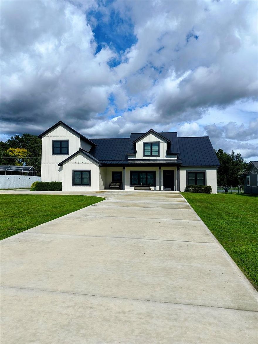 Welcome to this luxurious new home! This property offers two lakefront views on a 1-acre lot, ideal for boating and fishing, situated on Lake Ariana in the front and Lake Hart in the rear. The metal roof with 2" insulation will shine for years! The premium vinyl flooring offers the look of wood, with easy cleaning through out. The deep country sink allows for large pan cleaning, and the quartz counters give an elegant sight! Watch sunrise on the East end and Sunset on the West end.The residence features a spacious outdoor kitchen with a pizza oven, grill, sink, and cabinetry with lake view, perfect for relaxation and entertaining, with access to a 1/2 BATHROOM INSIDE THE GARAGE, providing accss to the backyard, outdoor patio, and kitchen. A door from the garage leads directly to the outside patio for added convenience. The outdoor kitchen is included with the purchase of the property.    The elegant interior includes a loft overlooking the great room and kitchen, complete with a pool table and a designated area for a laptop or computer or quiet reading or extra guests. Lake Ariana has a 40 foot deep access, where you could build your own dock to watch evening sunsets and watch sunrise from your rear patio area. The garage has a glossy sealed floor for easy sweeping. There is a boat ramp and private fishing pier adjacent to the property.