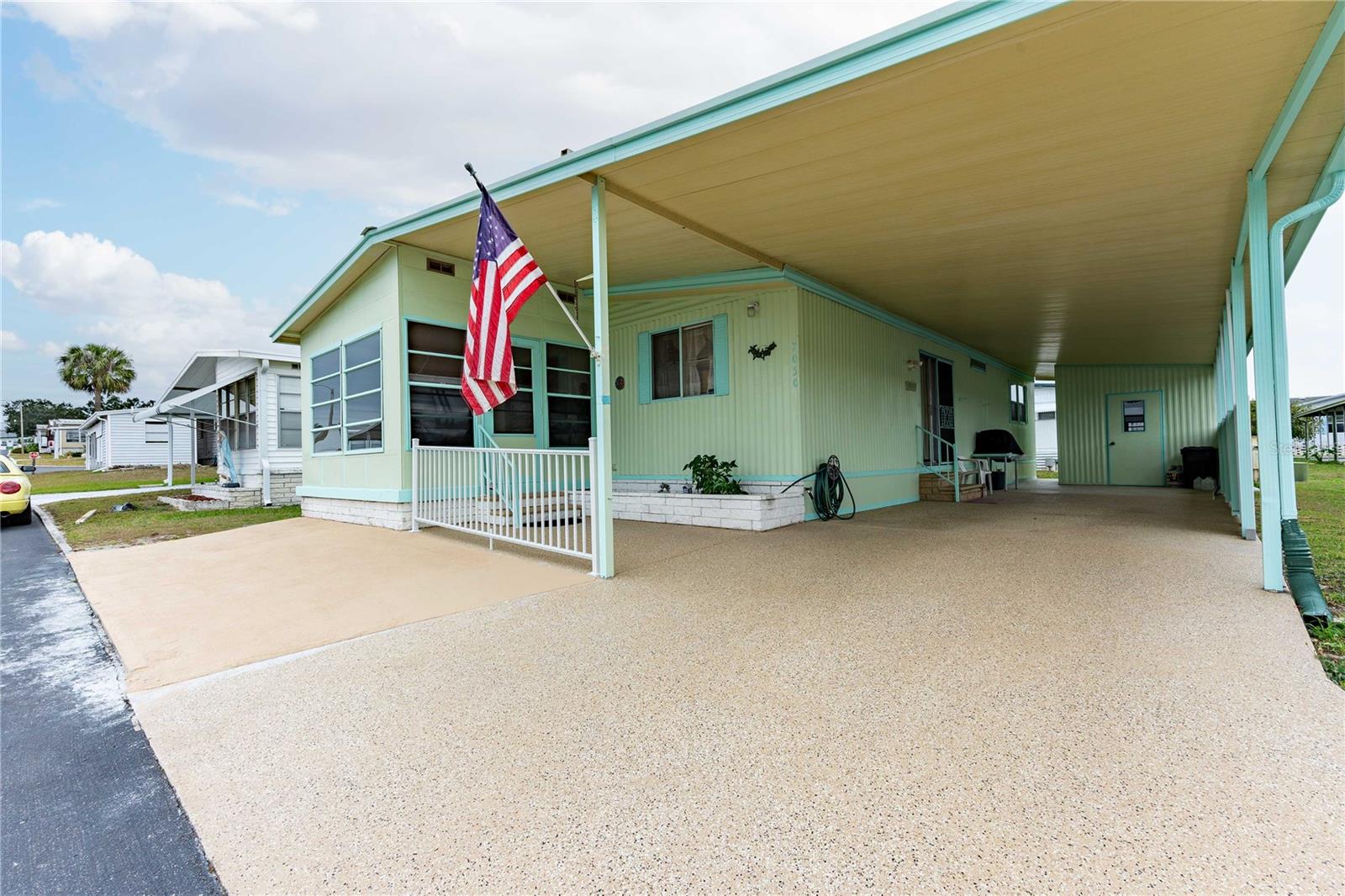 Welcome to Spanish Trails Village—an active 55+ GATED community where you own the land and enjoy a low HOA fee of just $129/month. This nicely maintained 2-bedroom, 2-bath home is move-in ready—just pack your bags and head to sunny Florida! Inside, you’ll appreciate the desirable open floor plan that connects the living, dining, and kitchen areas. The updated kitchen features newer appliances, refreshed cabinet doors, and upgraded flooring—perfect for any home chef. The dining area flows seamlessly into the living room, enhanced with laminate flooring and ceiling fans for comfort throughout. Sliding doors off the living room lead to the cheerful Florida room, an ideal spot for morning coffee, card games, crafting, or reading. Step outside to the covered front patio, where you can relax and enjoy those warm Florida breezes. The owner’s suite offers a spacious retreat with a large, updated step-in shower, a newer vanity, and a high-rise toilet. The second bedroom includes laminate flooring and a walk-in closet, while the guest bath has been upgraded with laminate flooring, a high toilet, and a stylish tub/shower combo with glass doors. Additional conveniences include a laundry area in the attached storage shed off the carport, providing both functionality and extra space. Spanish Trails Village residents enjoy fantastic amenities: a heated pool and spa, clubhouse, and active calendar of community events. All of this comes with low monthly fees, making it one of the best values in Zephyrhills. Centrally located near shopping, restaurants, and medical facilities, this home combines comfort, convenience, and community. Call today to schedule your private showing!