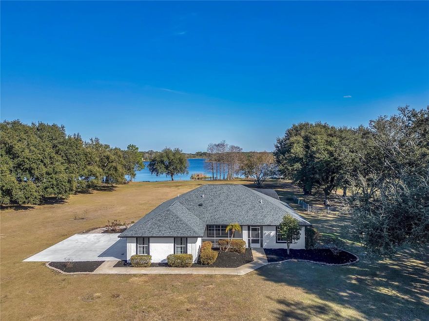 Stunning lakefront retreat on over 6.5 acres (4+ high and dry) in the heart of Groveland! This beautifully updated 3-bedroom, 2-bath home offers the perfect blend of privacy, comfort, and modern waterfront living. The interior has been completely remodeled with ceramic tile throughout, a brand-new kitchen featuring rich wood cabinetry and quartz countertops, and both the primary and guest bathrooms masterfully updated with contemporary finishes. Enjoy expansive living spaces filled with natural light and peaceful views of Lake Stewart. Step outside to a screened-in pool and spa, spacious paver patio, and your own dock and boat launch—ideal for boating, fishing, and unforgettable sunsets. A large detached storage garage/workshop provides ample space for boats, tools, and hobby projects, making this property truly versatile. With no HOA and acres of land, there is room to expand, build, or simply enjoy wide-open space and privacy. Located just minutes from Groveland’s exciting new downtown development, restaurants, shopping, trails, and waterfront parks, this home offers the rare combination of peaceful country living with convenient access to modern amenities. Additional highlights include vaulted ceilings, split-bedroom floor plan, updated fixtures, and a newer roof. Whether you’re searching for a full-time residence, weekend lake escape, or private retreat, this exceptional property delivers the very best of Florida lakefront living.