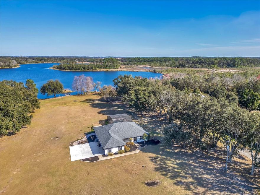 Stunning lakefront retreat on over 6.5 acres (4+ high and dry) in the heart of Groveland! This beautifully updated 3-bedroom, 2-bath home offers the perfect blend of privacy, comfort, and modern waterfront living. The interior has been completely remodeled with ceramic tile throughout, a brand-new kitchen featuring rich wood cabinetry and quartz countertops, and both the primary and guest bathrooms masterfully updated with contemporary finishes. Enjoy expansive living spaces filled with natural light and peaceful views of Lake Stewart. Step outside to a screened-in pool and spa, spacious paver patio, and your own dock and boat launch—ideal for boating, fishing, and unforgettable sunsets. A large detached storage garage/workshop provides ample space for boats, tools, and hobby projects, making this property truly versatile. With no HOA and acres of land, there is room to expand, build, or simply enjoy wide-open space and privacy. Located just minutes from Groveland’s exciting new downtown development, restaurants, shopping, trails, and waterfront parks, this home offers the rare combination of peaceful country living with convenient access to modern amenities. Additional highlights include vaulted ceilings, split-bedroom floor plan, updated fixtures, and a newer roof. Whether you’re searching for a full-time residence, weekend lake escape, or private retreat, this exceptional property delivers the very best of Florida lakefront living.