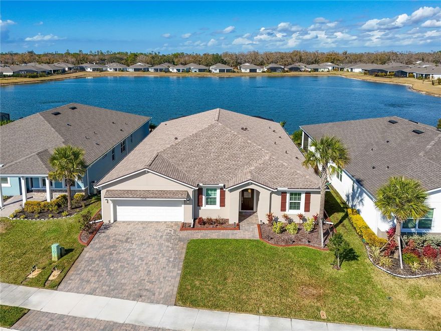 You just found your next home— where style, space, and smart upgrades come together in one exceptional home. Located inside the gated community of Windwater, this beautifully designed 4-bedroom, 3.5-bath home offers the perfect blend of functionality and Florida lifestyle. With a dedicated office/den and a spacious bonus room featuring French doors, there’s flexibility for working from home, a media room, playroom, or private guest retreat. The open-concept floor plan creates seamless flow between the living, dining, and kitchen areas — ideal for entertaining and everyday living. he kitchen is truly a standout, offering abundant countertop and cabinet space, making meal prep and storage effortless. A separate coffee bar or beverage station provides the perfect spot for morning routines or evening entertaining. The refrigerator features craft ice, adding a touch of luxury to your drinks, while the walk-in pantry ensures you’ll never run out of storage space. The spacious primary suite is designed for comfort and functionality, featuring two walk-in closets for exceptional storage. The ensuite bath offers split dual sinks, providing plenty of room to get ready with ease, and a beautifully designed walk-in shower with glass enclosure and dual shower heads. Bedroom 2 includes its own ensuite bath, great for guests or multigenerational living. Step outside to your extended paver lanai and experience true outdoor living at its finest. The panoramic screen enclosure frames peaceful views of the lake while the fully equipped outdoor kitchen — complete with flattop grill, traditional grill, two refrigerators, and a wine cooler — makes hosting effortless. With three mounted TV locations, this is the ultimate game-day and gathering space. Major upgrades in 2025 provide peace of mind for years to come, including: Brand-new roof with 50-year shingles, hurricane-impact windows and doors, gutters, and interior and exterior paint. The laundry room has added cabinets for additional storage. The three-car tandem garage offers overhead storage, and the extended driveway provides parking convenience. Windwater residents enjoy gated security, a community pool, paw park, and tot lot — all with NO CDD fees. This home truly checks every box: space, upgrades, outdoor living, and community amenities. Schedule your private showing and experience it for yourself.