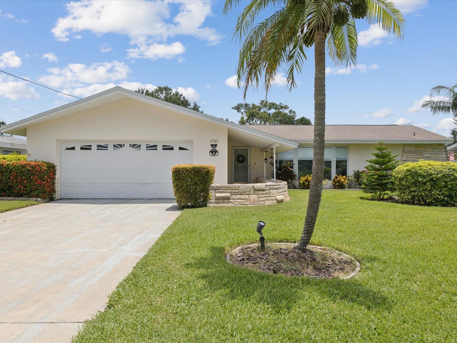 Welcome to this beautifully maintained 3-bedroom, 2-bathroom home in the highly sought-after Harbor Hills neighborhood! Situated on one of the highest points on the block, this property remained untouched by flooding and offers peace of mind in both location and condition. Zoned for A-rated Anona Elementary, this home features a desirable split floorplan, excellent curb appeal, and pristine landscaping with plenty of room for a pool. Nestled towards the back of the neighborhood, on a no-through-traffic street, this golf cart-friendly community allows you to easily cruise to nearby restaurants, shops, and some of America’s finest beaches. Enjoy the Florida lifestyle from your 400 sq. ft. covered rear porch, complete with pass-through kitchen windows—perfect for entertaining or relaxing in the serene outdoor setting. Inside, you'll find two spacious living areas, large bay windows, and four sets of sliding glass doors that provide an abundance of natural light. The oversized 2-car garage, newer carpet, and charming terrazzo floors add both functionality and classic appeal. The primary suite includes an expansive en-suite bathroom and generous closet space, while the guest bath offers dual vanities and a tub ideal for little ones. Both guest bedrooms are ideal in size and provide ample closet space. Whether you're sipping your morning coffee on the patio or hosting an evening gathering, this home offers the perfect blend of comfort, convenience, and coastal charm.