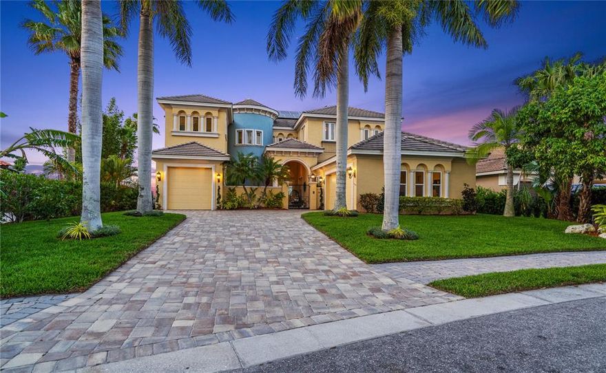 Spectacular riverfront estate with panoramic sunset views of the Manatee River. This residence is situated on a private street behind a staffed guard gate and backs up to wide open views and boating access. Highlighting the incredibly functional layout, the great room will greet everyone as the focal point of the first floor, featuring 25-foot vaulted ceilings, a gas fireplace, and large glass sliding doors boasting dramatic pool and water views. The well-appointed chef’s kitchen features a center island with a secondary prep sink, a wraparound bar with plenty of room for seating, a built-in hidden fridge, a 5-burner gas cooktop with luxuriously custom diamond-shaped tile backsplash, a multitiered dishwasher, countertop glass cube windows, soft-close drawers and solid wood cabinets with accent lighting. The expansive owner’s retreat features access to the Florida room, along with a large bay window with views of the water, dual walk-in closets, and a large bath boasting split vanities with vessel sinks, a makeup counter, a built-in deep soaking bathtub, separate water closet and glass walk-in shower with custom stone tile flooring. The second level of the home can be accessed through the stylish wood spiral staircase featuring tile accents, custom lighting, pocket windows and an iron banister, or through the home’s personal elevator with glass doors. The first-floor features 12-foot ceilings, 18-inch ceramic tile flooring, a designated office and a gorgeous guest suite with sliding glass door access to the pool lanai. The second level showcases a second oversized bedroom with dramatic water views and access to the Florida room, as well as an additional bedroom designed as a lounge area containing a wet bar and wine rack. Other features of this home include large crown molding throughout, tray ceilings, architectural accents throughout, solar panels providing power for the home, an inviting brick paver courtyard at the main entrance, split garages, attached shed for lawn and pool equipment, and all the windows and sliding glass doors in the home replaced in 2014 and feature hurricane-resistant glass. Outdoor water amenities abound, leading off with the screened-in pool and lanai. The pool contains both a fountain and waterfall, and is surrounded by a large, travertine lanai featuring ample covered or open seating area options. The property also benefits from a long fishing dock behind the home extending out into the open water, as well as a small beach for a direct kayak or paddleboard launch into the river, and an additional boat dock on an inlet across the private road from the home. Located conveniently in Bradenton, this property benefits from being located near multiple golf courses such as River Isles, River Run, River Strand, and Heritage Harbour, as well as Tom Bennett Park and the Ellenton Premium Outlets. All of this, just a short drive to downtown Bradenton, Manatee Memorial Hospital, convenient interstate access, and a straight shot down SR-64 to Anna Maria Island and the local Gulf beaches.
