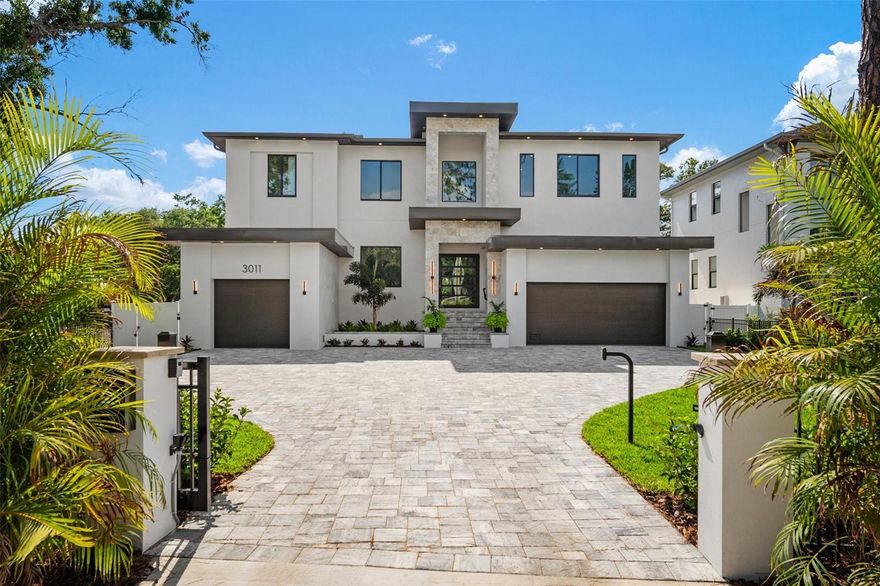 Now Ready!  Stunning new luxury home with four car garage, private gate and fabulous pool/spa situated on a very large lot in Sunset Park.  
A rare find in South Tampa – large .38 acre lot allows for large front yard with private motorized entrance gate and large paver motor court, as well as, deep backyard with outdoor Kitchen, gorgeous Pool featuring sunshelf & infinity edge Spa, LED lights, gas heater & salt chlorinator.  
The 5,297 square foot home with over 7,200 square feet under roof has an open floor plan with beautiful modern styling.  There are a total of five bedrooms all with en-suite bathrooms and two half-baths.  
Focal point of the home is a modern metal staircase with thick wood treads with dramatic free-form lighting.   Great Room has faux-finished accent wall with built-in shelving and large four panel 16’ sliders and large Kitchen with walk-in Working Pantry and Wolf/Subzero/Bosch appliances, custom wood cabinetry and quartz counters, backsplash and waterfall edges.  Dining area is open to the custom LED and glass Wine Closet and Wet Bar with ample storage and beverage refrigerator tower.   A beautiful First Floor Master/Guest Suite includes large walk-in closet and private bathroom with lovely floor to ceiling tile, pendant lighting and LED mirror.  Also downstairs is a tray ceiling in the Foyer, a large bright Office, Powder Bath, and the Mud Room includes connections for refrigerator and washer/dryer.

Upstairs are three more bedrooms – all with private bathrooms and walk-in closets – plus the Primary Suite which features LED tray ceiling, dual walk-in closets with custom built-in shelving including glass front display units and hampers and a large luxurious bright Master Bathroom with large format tile, dual vanities with motion detection LED toe-kick lighting and accented by wall sconce lights, a freestanding tub set by a large picture window and a big glass enclosed shower with multiple shower heads and a bench, a separate toilet room.

The Bonus Room has an LED accented cloud ceiling feature, impressive Wet Bar with floating shelf and tiled backsplash and a half bath.

On the rear Lanai is custom Outdoor Kitchen with stainless steel grill, hood, beverage fridge, and accessories and featuring a beautiful natural stone counter with bar seating and tile backsplash.  Large oak and lush landscaping provide privacy and a beautiful setting.

Many quality features from an experienced South Tampa builder - block construction, spray insulation for reduced energy costs, large attic storage area with pull down stairs 11’ 4” and 10’ ceilings, beautiful wood flooring, modern trim and doors, ample recessed can lights, premium lighting and plumbing fixtures, pre-wiring for many data, security and audio/visual options including wall-mount televisions, cameras, speakers and automation.