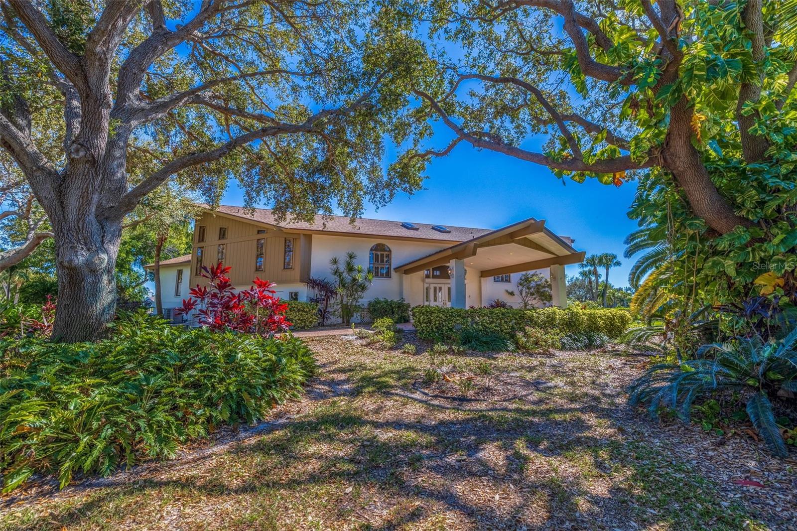 Dreaming of the Florida lifestyle? Relax and retreat to this one-of-a kind ELEVATED, WATERFRONT home on the sought after island of Tierra Verde. Situated on a sprawling corner lot surrounded by lush landscaping sits this Swedish Long House style home, which was originally custom built for the musical group ABBA. It features a paved, circular driveway with a grand porte-cochere. Step into the home where you are greeted by a bright, sky-lite foyer that opens to the spacious great room with soaring ceiling, a floor to ceiling imported stone, gas fireplace and views of the salt-water canal. Offers 4,527 sq. ft. of living space with 6-bedrooms and 4 bathrooms plus 2 half baths. It has a unique design as it is divided into two identical “Mirrored” floor plans that branch off the large great room so that quests or family can retreat to their own living space. Each side includes: a first-floor master suite with an ensuite bathroom with a jacuzzi tub and walk in closet, a second-floor loft area and two bedrooms with a Jack-and-Jill bathroom. The large covered deck with a hot tub overlooks the salt water canal, heated in-ground pool with paved deck and the Trex boat dock. Both sides have a 2-2 garage with separate entrances and abundance of storage capacity. Recent upgrades include a new roof, skylights, battery ready solar panels, three zone HVAC system, and fresh paint inside and out. 2 new Rheem HYBRID 50 gallon water heaters-most efficient electric/solar heat pump water heaters. The windows and sliders are hurricane protected with electric shutters (entire back of house) or plexiglass (front windows). Located only 30-40 minutes from 2 international airports via I-275, 5 minutes to the Sunshine Bridge,10 minutes to downtown St. Petersburg with its cultural attractions, entertainment, and fabulous restaurants. 5 minutes to award winning St. Pete Beach and Fort DeSoto – an 1100 acre park offers sugar sand beaches, camping, kayaking and miles of nature trails – is right in our backyard. AND miles of trails!