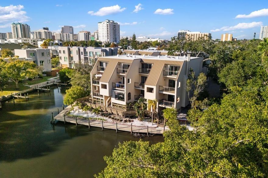 One or more photo(s) has been virtually staged. Experience easy, coastal living in this two-story, two-bedroom, two-and-a-half-bath townhouse overlooking the tranquil Hudson Bayou, with direct access to Sarasota Bay. This quaint waterfront community offers a private boat dock and kayak launch, making it ideal for those who enjoy life on the water.

Perfectly situated in downtown Sarasota, you’re just one block from Burns Court, three blocks from Main Street, and directly across from Selby Gardens and the Bayfront. The Legacy Trail, Lido & Siesta Key Beaches, and all the cultural, dining, and shopping amenities Sarasota is known for are just minutes away.

The setting is peaceful and leafy, surrounded by mature trees and adjacent to historic Laurel Park, creating a true neighborhood feel. Residents enjoy a pool and gas grill, while practical features include a garage with private EV hook-up and private storage room beneath the building.

A rare combination of walkability, waterfront access, and serenity, this home offers a high quality of life in one of Sarasota’s most desirable locations.