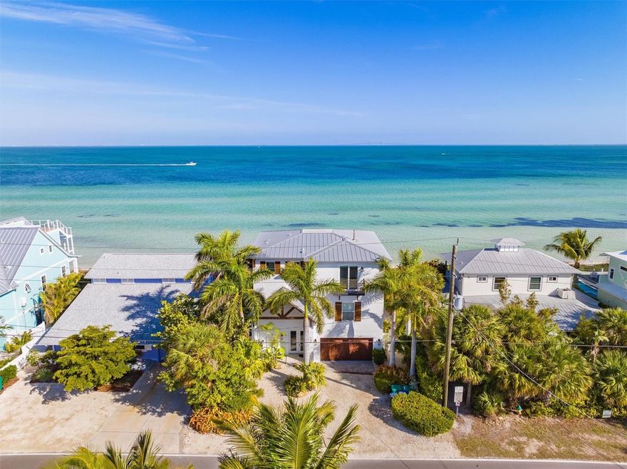 DIRECT TAMPA BAY WATERFRONT!!!  The magic of Anna Maria Island shines throughout this fabulously maintained home with direct Tampa Bay frontage with sweeping views that brings the unobstructed Skyway bridge right into your back yard!  And, unlike Gulf front homes, the sandy beach in front of this home is private!  Only a few short blocks to the shops and restaurants on Pine Avenue and Galati’s Marina this island chic home features a large open floor-plan living area, dining and kitchen, 4 bedrooms and multiple extensive balconies overlooking the most spectacular sunrise over the bay.   This waterfront retreat is built all block and to the highest standards and offers impeccable finishes throughout, including a mirrored elevator to all floors, gourmet kitchen, gorgeous chandeliers, custom tile work, custom staircase railing and more.  The gourmet kitchen showcases custom cabinetry, quartz counter tops, gas range, and high end Jenn air stainless steel appliances.  There is a 2 car garage and 4 additional parking spaces in the driveway.  Step outside to enjoy our very own tropical paradise featuring a large dining table and grill to cook and entertain, covered area to take shade from the sun, spacious heated pool with a sun shelf for lounging, AND your very own private sandy beach area to play and launch the kayaks!  All while overlooking the beautiful waters of Tampa Bay and the nature it brings to your backyard, it never stops to amaze.   Views from every room of dolphins and sailboats during the day, and the twinkling lights of the Skyway Bridge at night, you don’t want to miss out on this stunning piece of property!  Great investment and popular vacation rental with $384k in rental income for 2023.