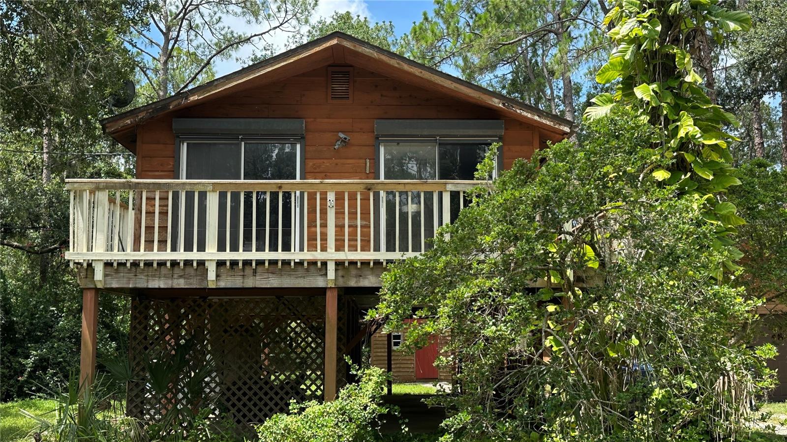 This is a stilt home located in an equestrian community with no HOA. This home needs fixing up. It is the perfect starter home with some elbow grease. Proof of funds required prior to showing. Appointment needed. No flood insurance required located on 1.2 acres. Partial backyard in flood zone. Well & septic. Work shop with laundry just yards away. Separate oversized garage, totally fenced yard with chain link fencing. Parking available under home or could be extra storage for toys.