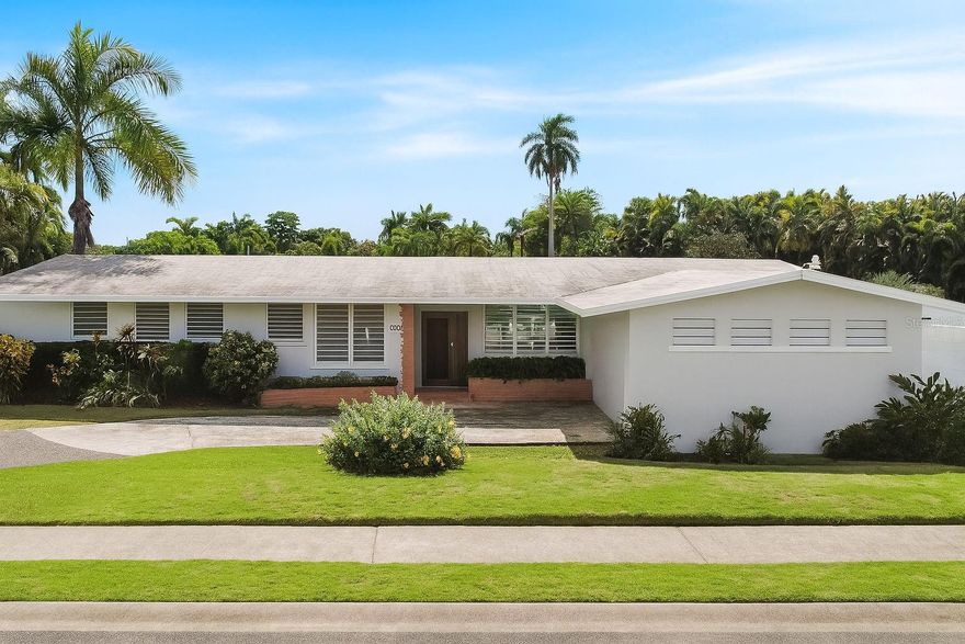 Experience the perfect blend of elegance, spaciousness, and an unbeatable location in this distinguished residence located in Garden Hills Norte, one of Guaynabo’s most exclusive, secure, and sought-after communities. Its serene atmosphere, wide streets, and controlled access create the ideal setting for a comfortable and stylish family life.

From the moment you enter, this property captivates with its classic architecture and four-sided gabled roofs reaching 12-foot-high ceilings, providing natural light, ventilation, and a remarkable sense of openness. Every detail has been carefully designed to bring functionality without sacrificing elegance, creating spaces that invite daily enjoyment.  

Layout and main features:
• Five spacious bedrooms, three of them with en-suite bathrooms, ensuring maximum comfort and privacy for every family member (4.5 bathrooms total).
• 2,923 square feet of construction on a 1,040.7 square meter lot, offering an excellent balance between indoor and outdoor living space.
• A modern and functional kitchen featuring granite countertops, ample storage, and an ideal layout for those who enjoy cooking or sharing family moments.
• A concrete terrace, perfect for social gatherings, barbecues, or simply relaxing at the end of the day while enjoying the tropical breeze.
• Double garage with driveway and an additional side garage, providing total parking capacity for up to four vehicles.
• Independent laundry area with extra storage space.
• Power generator and solar water heater, ensuring energy efficiency and peace of mind in case of unexpected outages.

Located in the heart of Guaynabo, this residence offers direct access to the best of urban and family living. Just minutes away are San Patricio Plaza, Suchville Plaza, and Garden Hills Plaza, where you can enjoy restaurants, boutiques, gyms, and essential services. It’s also steps from the exclusive Caparra Country Club and Torrimar Sports Complex, ideal for recreational, athletic, and social activities.

For families, the location couldn’t be more convenient — within close proximity to some of Puerto Rico’s most famous schools, including Maristas, Baldwin School, and Gersh Academy. It also offers quick access to the Tren Urbano station and main highways connecting to San Juan, Bayamón, and Dorado, making commuting simple and efficient.

This property is more than just a house — it’s a lifestyle. It offers the perfect balance of comfort, elegance, and convenience within a community where security and a sense of belonging are top priorities. Ideal for those seeking to elevate their quality of life, embrace tranquility, and enjoy everything Garden Hills Norte has to give