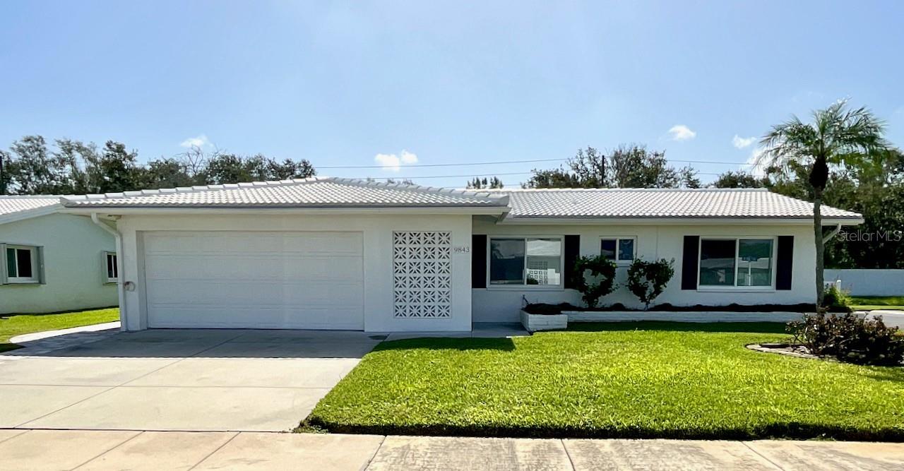 Here it is! That rare home with 3 bedrooms, 2 bath, and 2 car garage deluxe Drayton model, with 1517 sq ft, in the desirable 55+ golf cart community of Mainlands of Tamarac by the Gulf. This home is located on a corner lot at the end the street on a quiet cul-de-sac. There is a 2-car driveway with an extra space on the side for your golf cart. Entering the home, you will notice deluxe luxury vinyl flooring throughout and tile in the baths. The kitchen has updated soft close cabinets, granite counter tops, and a large pantry cabinet with pull out drawers. There are additional open shelves for added storage. The large family room is perfect for entertaining with a door to the enclosed, covered, screened lanai. The enclosed lanai has attached a 12 x 15 outside, open-air patio. At the opposite end of the family room is a bedroom with a built-in desk and closet. The hallway off the living room leads you to the guest and the primary bedroom. Both bedrooms have walk-in closets. The guest bath and the primary bath have been beautifully updated with step-in showers. There is an additional closet in the hallway for extra storage. This home has impact windows and a whole house vacuum. In the garage there is loft storage, a pull-down ladder to the attic, a sink with a stacked washer and dryer. The air-conditioner was replaced in 2020. Unit 4 residents enjoy access to a clubhouse with a heated pool, a library, and a variety of social activities such as dances, card games, and shuffleboard. Conveniently located just minutes away from the Mainlands Public Golf Course, Mayor Park, airports and downtown St. Petersburg. This unique property is just waiting for you. Call today to schedule your showing!